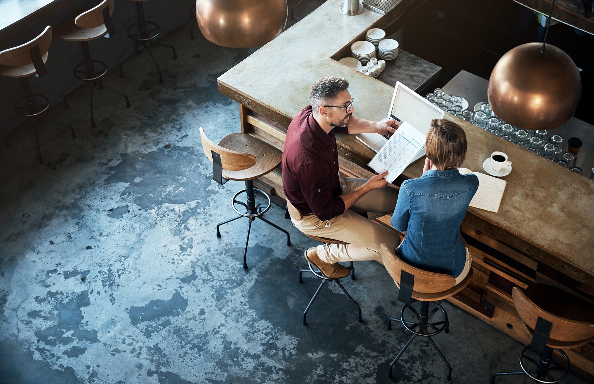 Zwei Geschäftsleute arbeiten am Tresen eines Cafés.