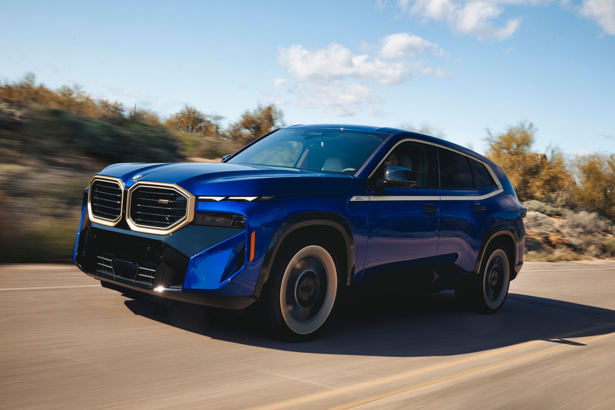 Ein blauer SUV von BMW auf einer Landstraße. Ein blauer SUV von BMW auf einer Landstraße.