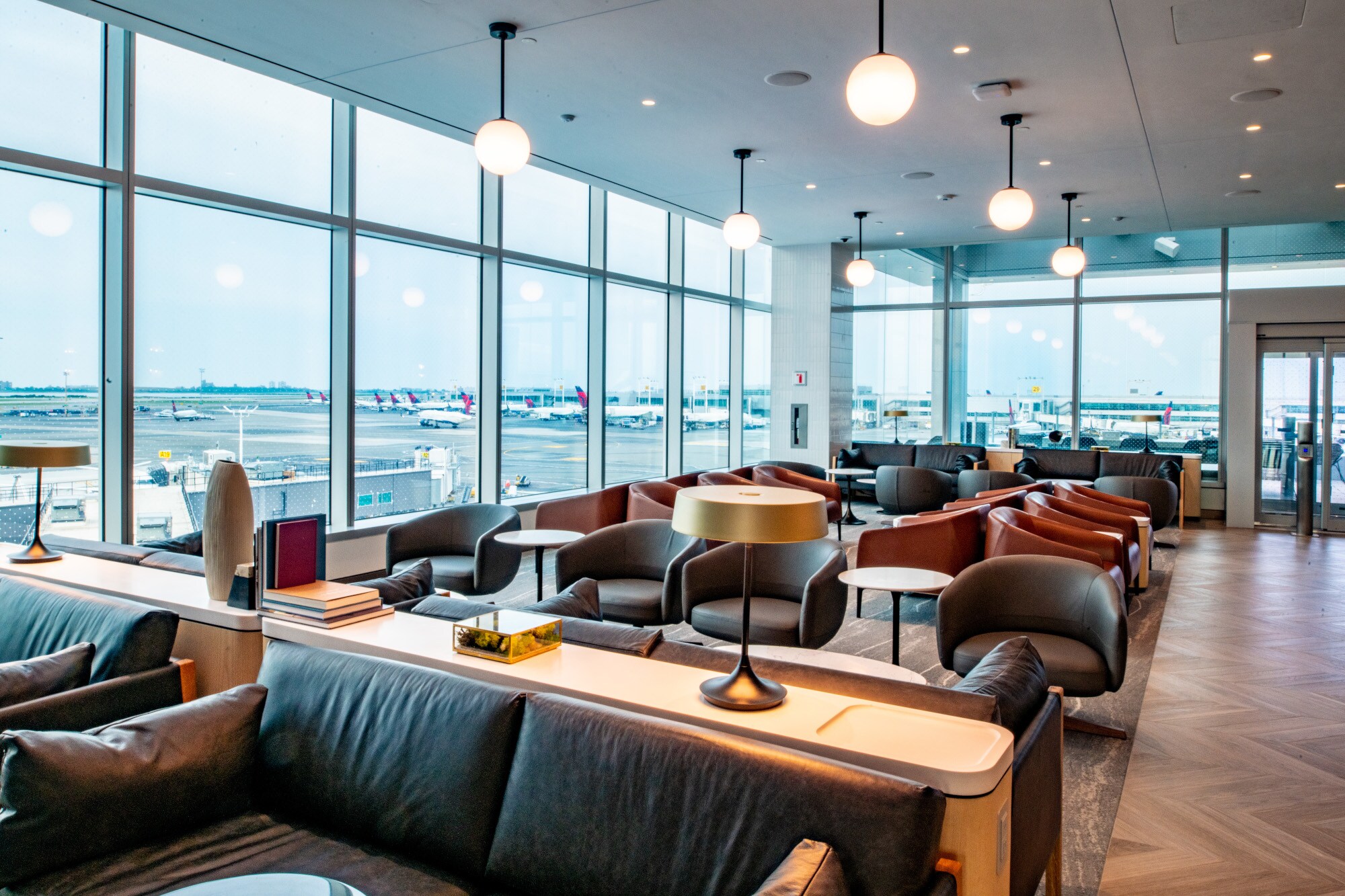 Helle und moderne Flughafenlounge mit Blick aufs Rollfeld durch Panoramafenster. Helle und moderne Flughafenlounge mit Blick aufs Rollfeld durch Panoramafenster.