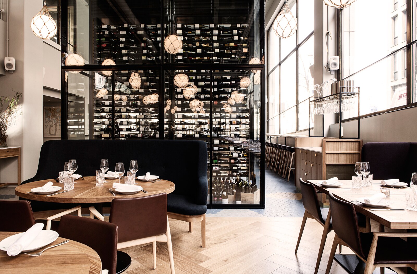 Modernes, helles Restaurant mit hohen Fensterfronten und Holzmöbeln im skandinavischen Design. Modernes, helles Restaurant mit hohen Fensterfronten und Holzmöbeln im skandinavischen Design.