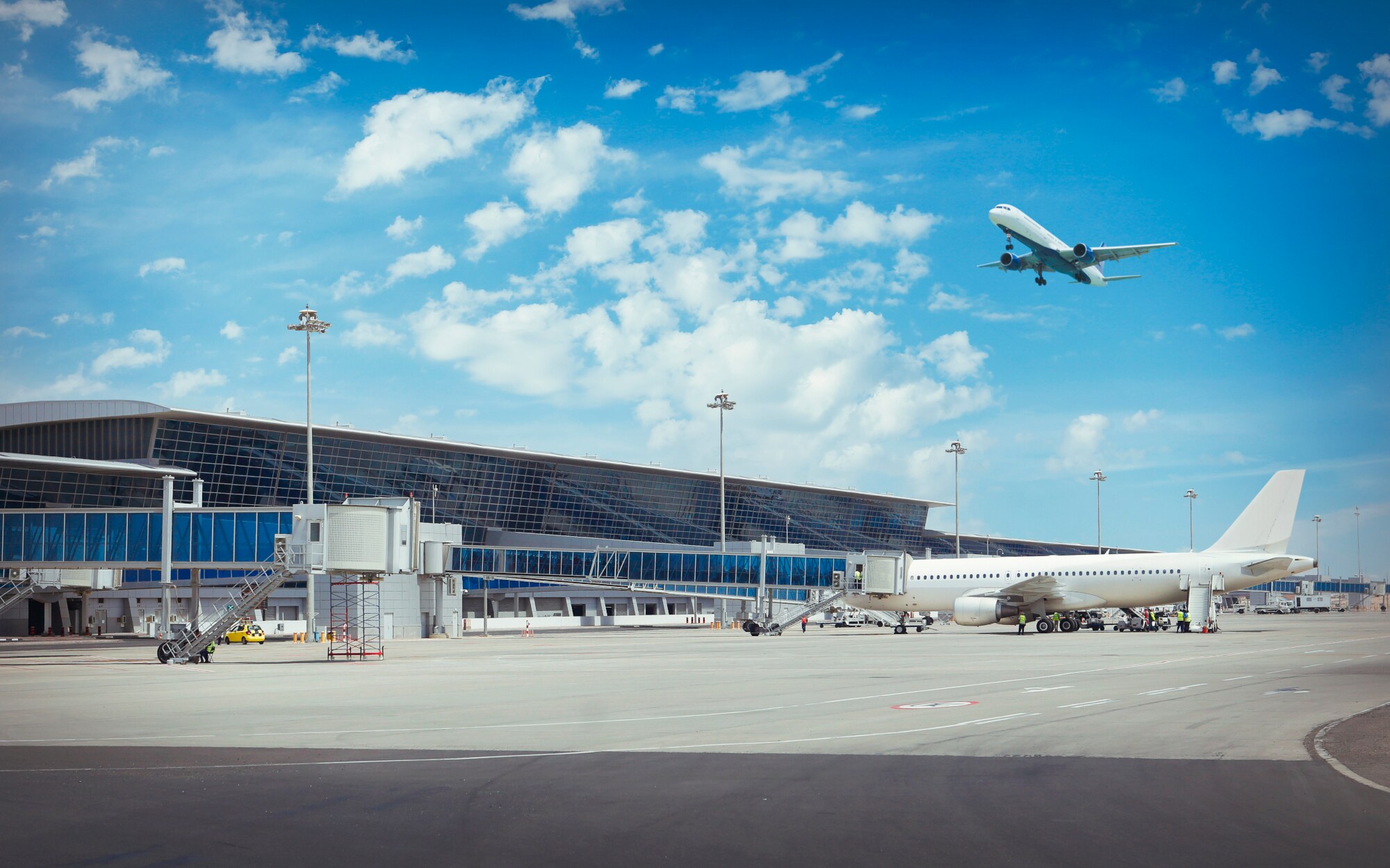 Flughafenterminal, über den ein Flugzeug fliegt.