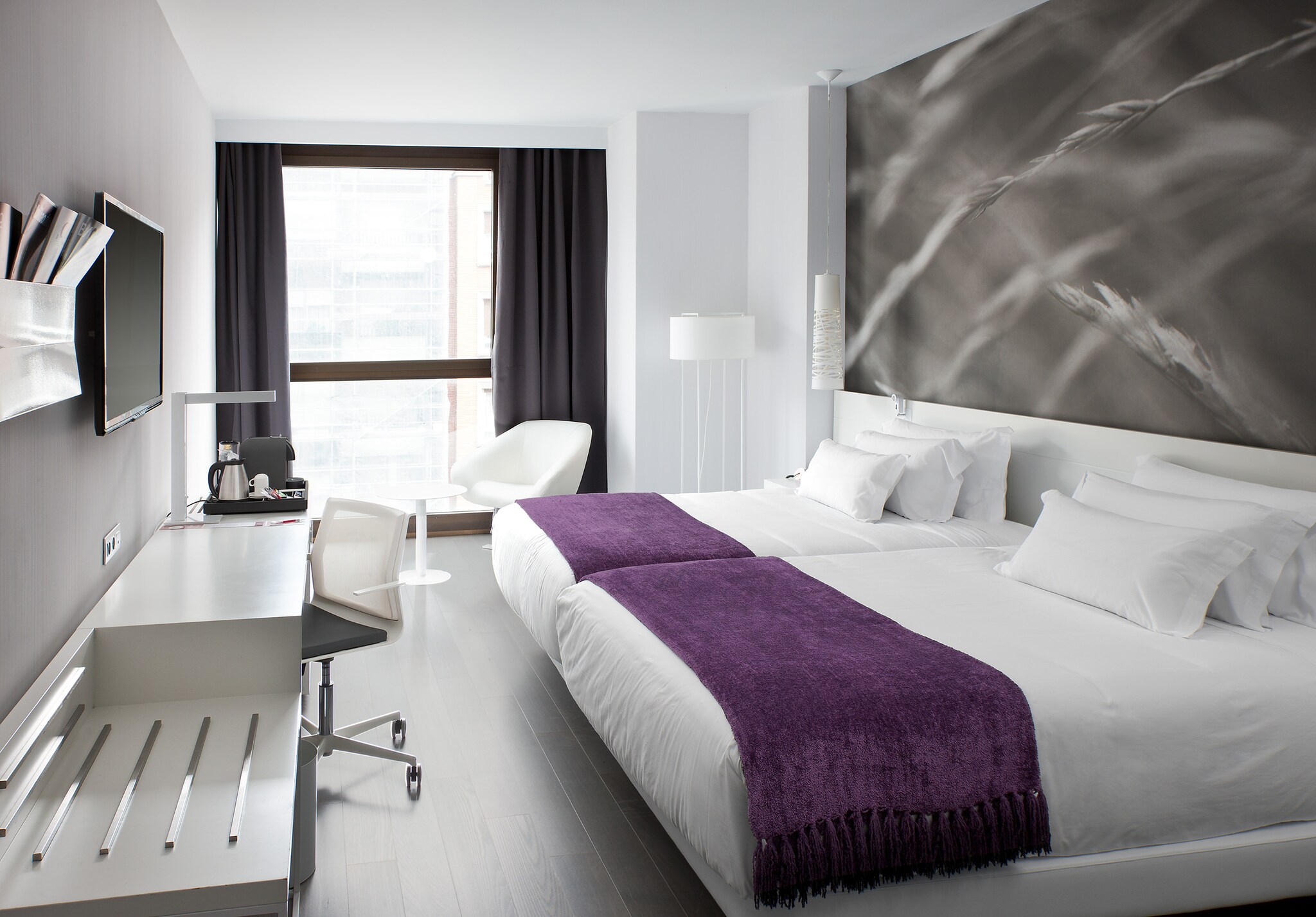 Helles, modernes Hotelzimmer mit Doppelbett.