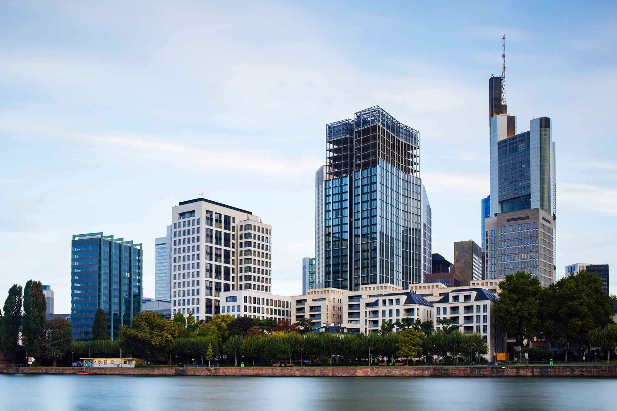 Das Foto zeigt das Mainufer und Hochhäuser in Frankfurt am Main.