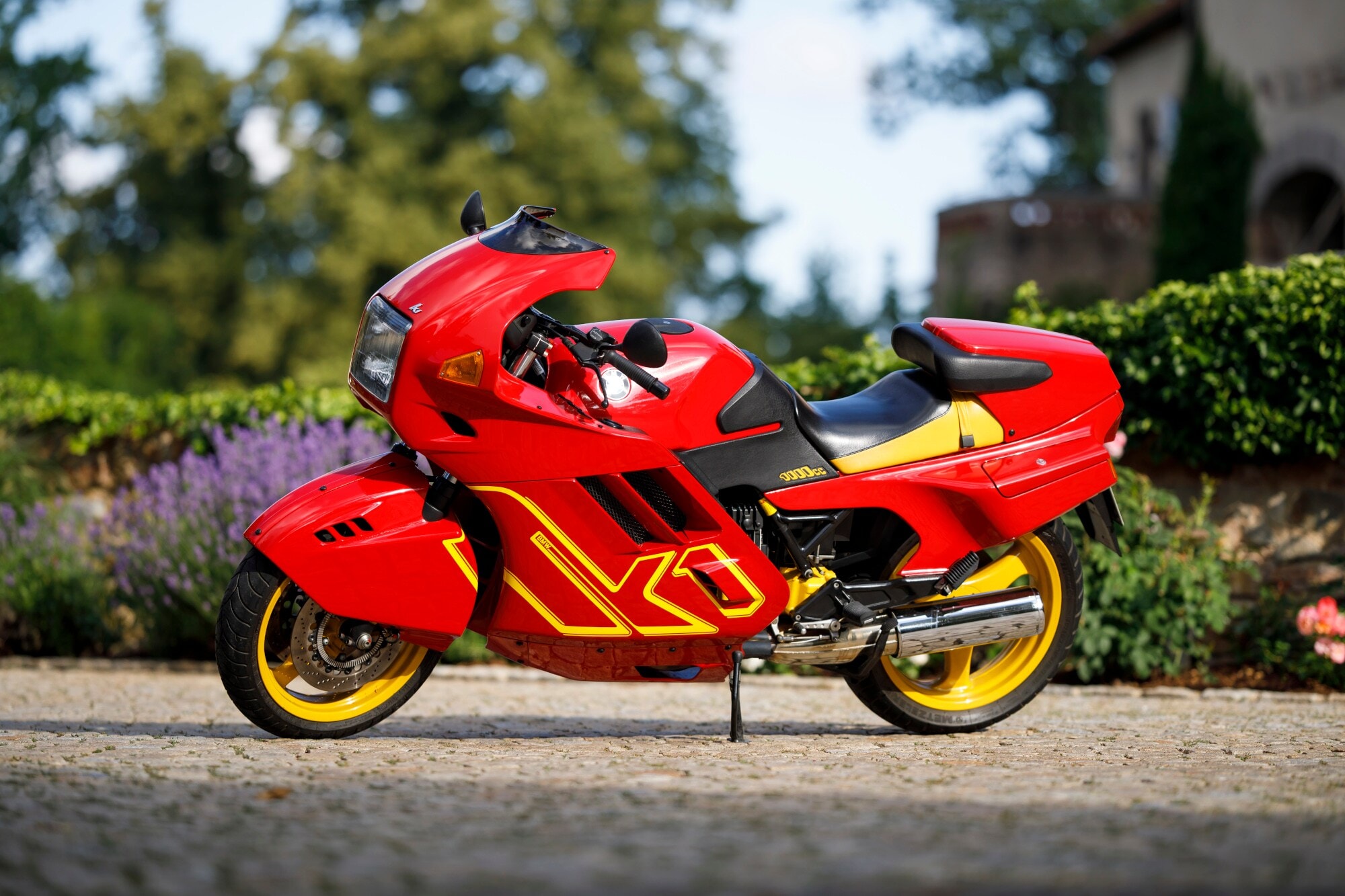 Vollverkleidetes Sportmotorrad K1 von BMW in Rot, geparkt auf einer Straße. Vollverkleidetes Sportmotorrad K1 von BMW in Rot, geparkt auf einer Straße.