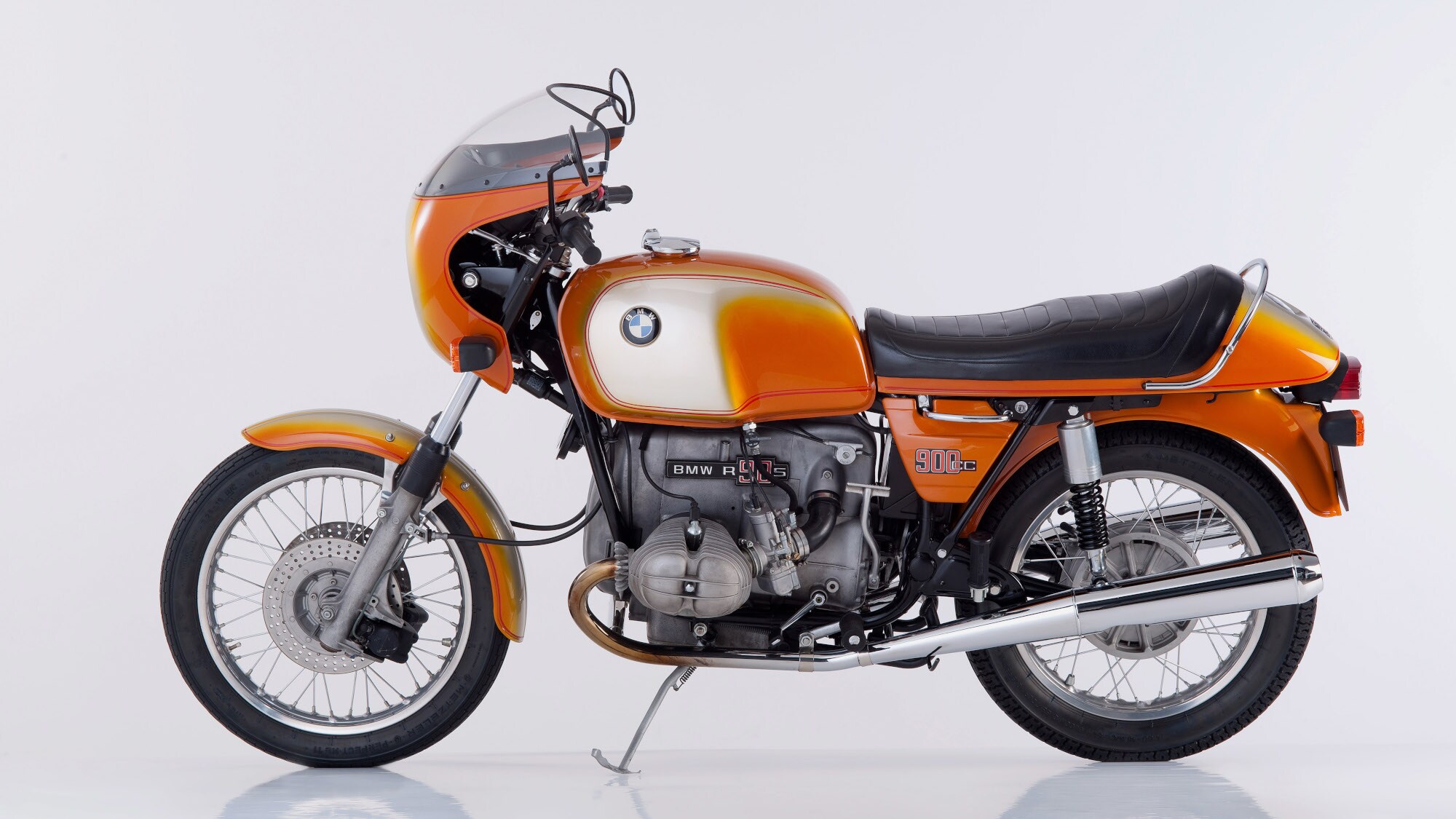 Orangefarbenes Motorrad R 90 S von BMW, Studioaufnahme vor weißem Hintergrund. Orangefarbenes Motorrad R 90 S von BMW, Studioaufnahme vor weißem Hintergrund.