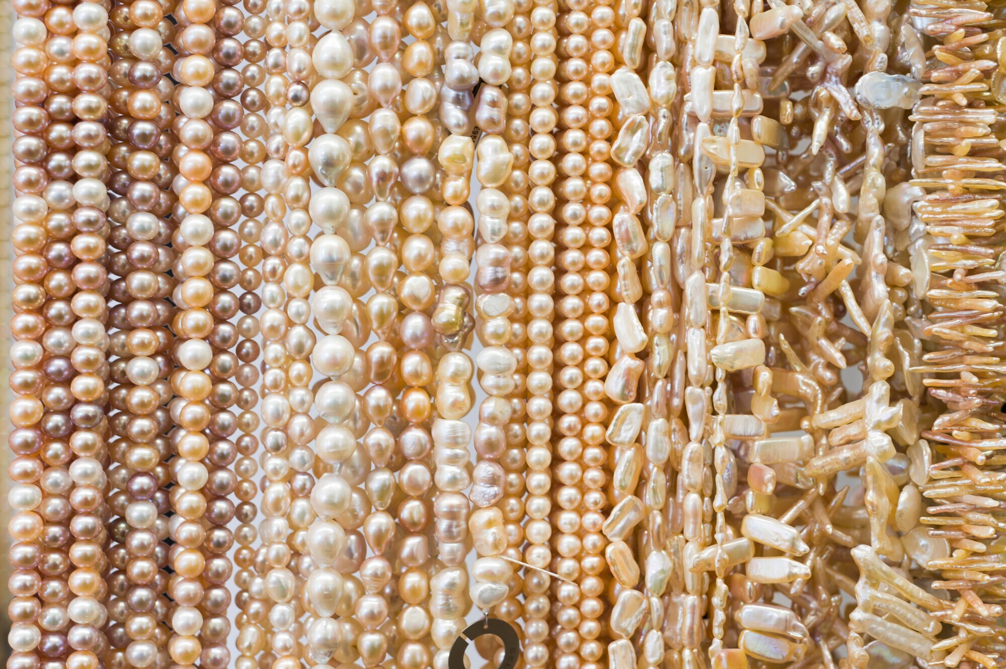 Viele Perlenketten mit unterschiedlichen Perlen dicht nebeneinander Viele Perlenketten mit unterschiedlichen Perlen dicht nebeneinander