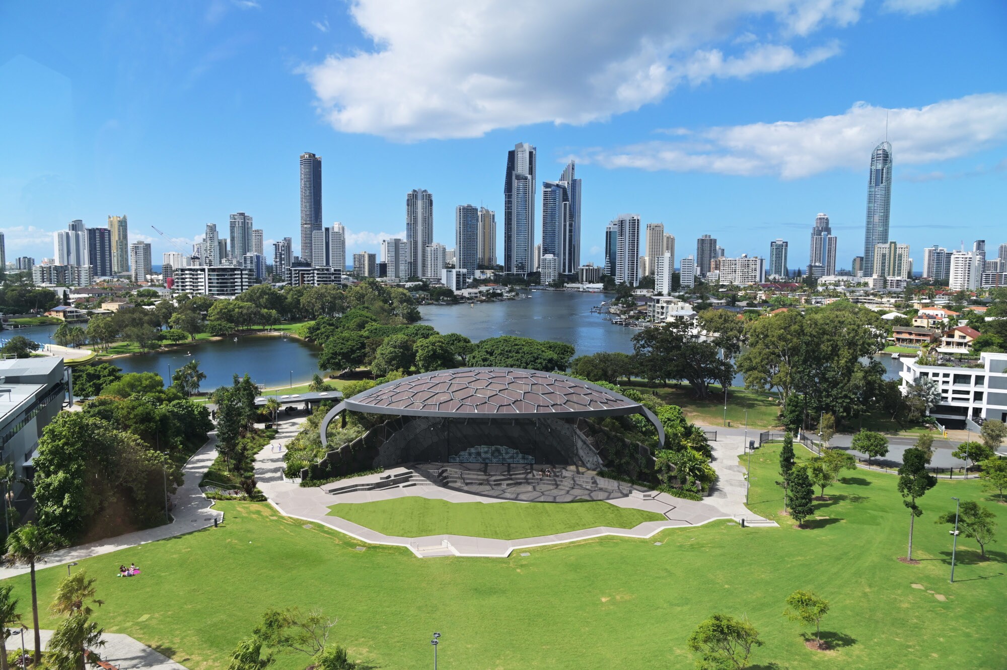 Modernes, muschelförmiges Kulturzentrum mit Parkanlage an einem See vor der Skyline von Surfers Paradise.