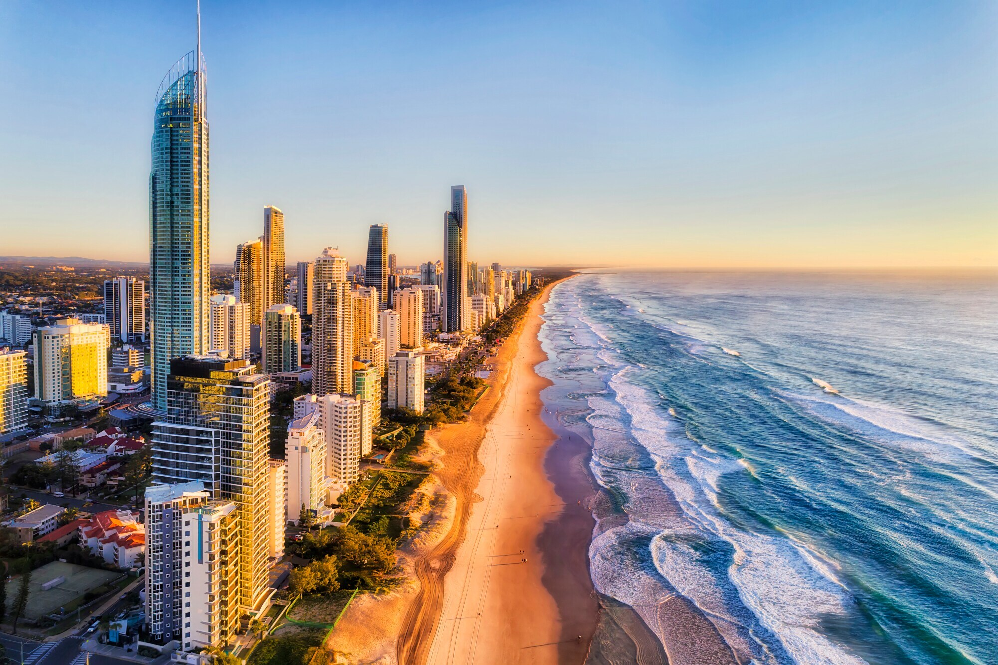 Luftaufnahme der Skyline von Surfers Paradise am kilometerlangen Sandstrand bei goldenem Sonnenlicht. Luftaufnahme der Skyline von Surfers Paradise am kilometerlangen Sandstrand bei goldenem Sonnenlicht.