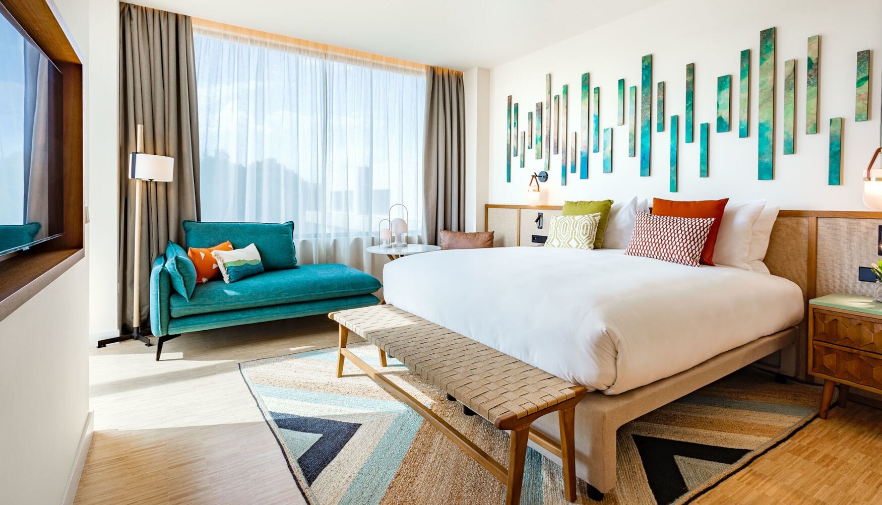 Ein helles, modernes Hotelzimmer mit Doppelbett und farbenfrohen Gestaltungselementen. Ein helles, modernes Hotelzimmer mit Doppelbett und farbenfrohen Gestaltungselementen.
