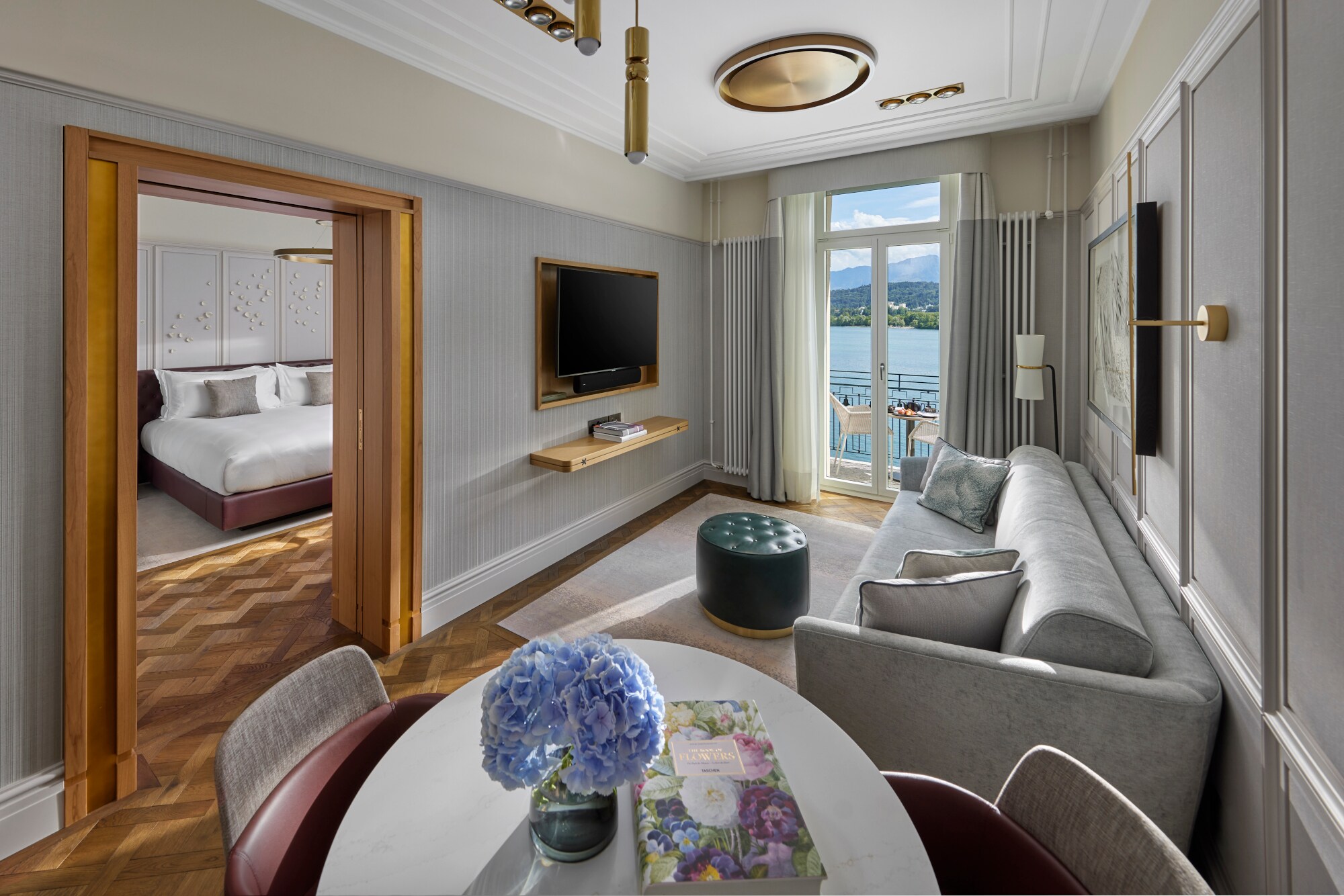Elegante Hotelsuite mit Balkon an einem See vor Bergpanorama. Elegante Hotelsuite mit Balkon an einem See vor Bergpanorama.