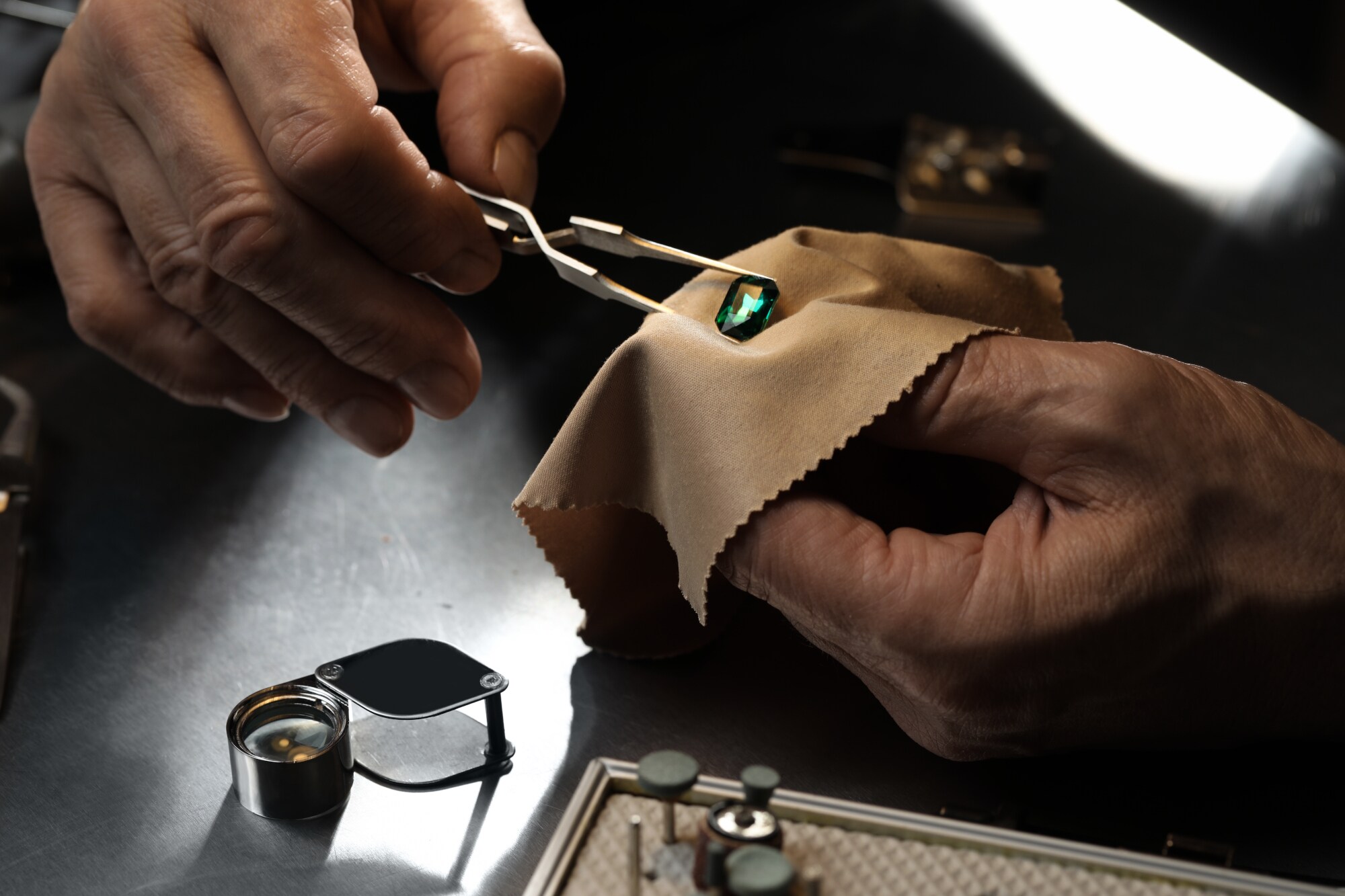 Nahaufnahme eines professionellen Juweliers, der mit einem geschliffenen Edelstein arbeitet Nahaufnahme eines professionellen Juweliers, der mit einem geschliffenen Edelstein arbeitet