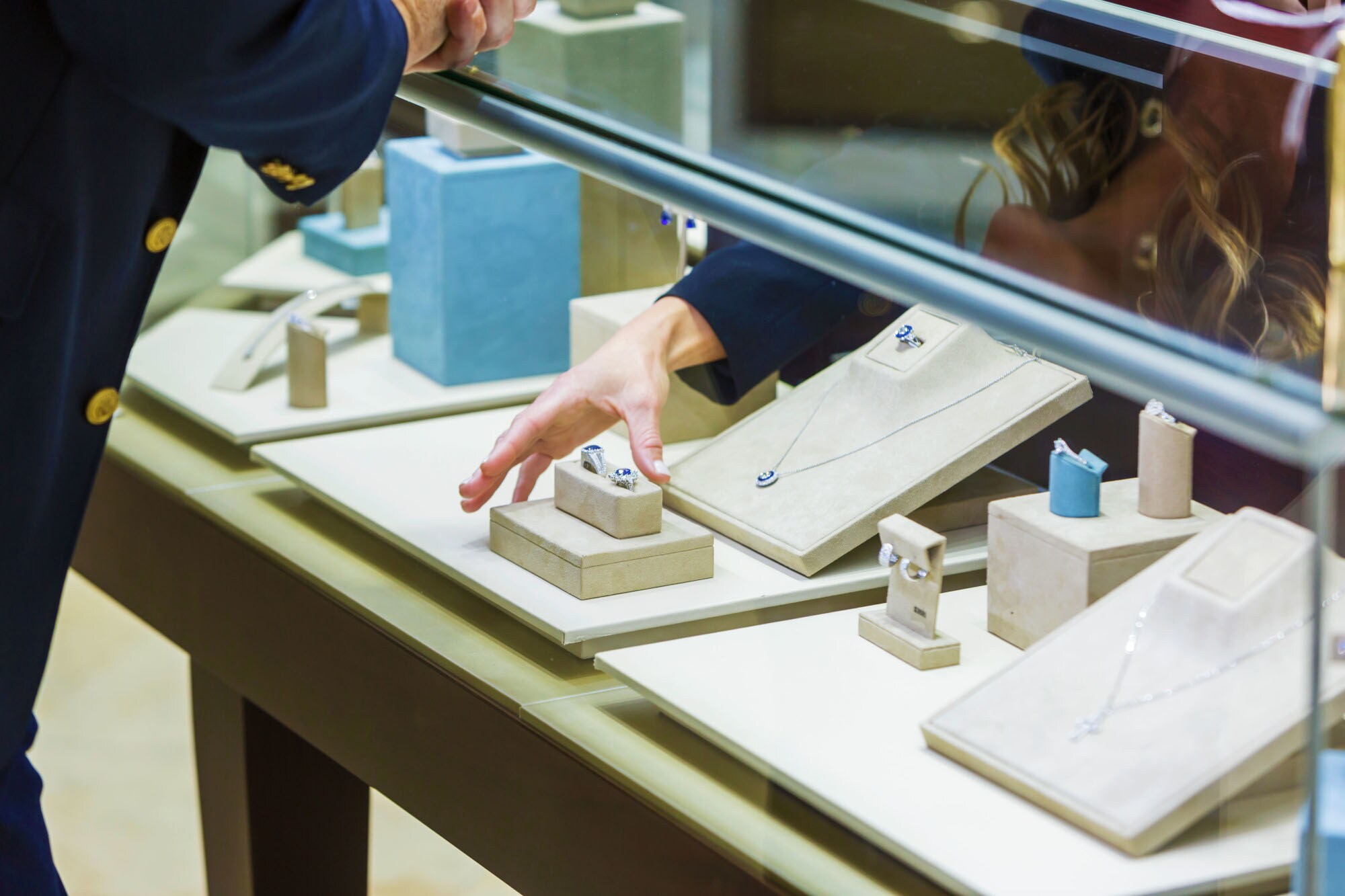 Verkäuferin hilft einem Mann bei der Schmuckauswahl