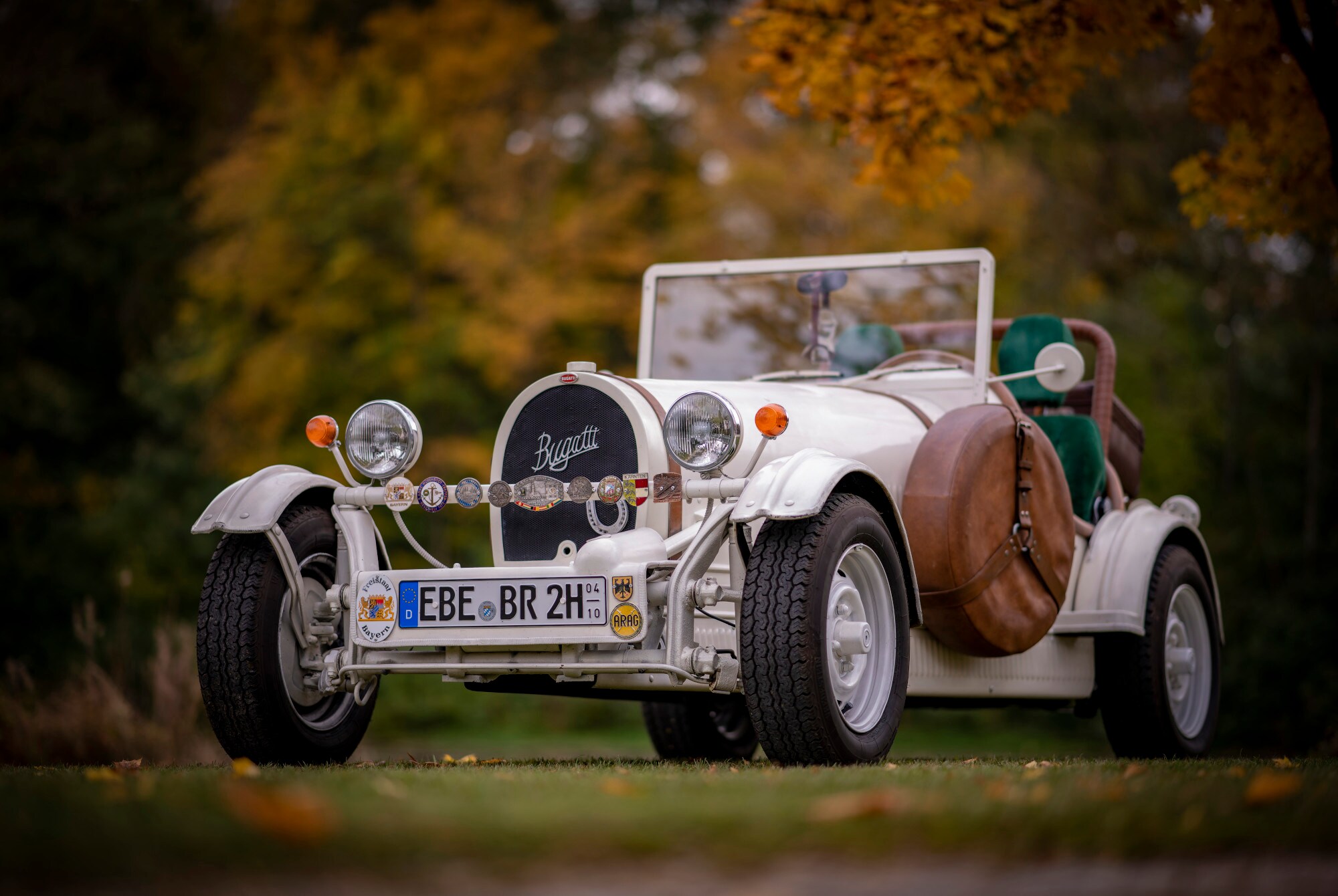 Weißer Bugatti Cabriolet Oldtimer mit H-Kennzeichen in einem Park.
