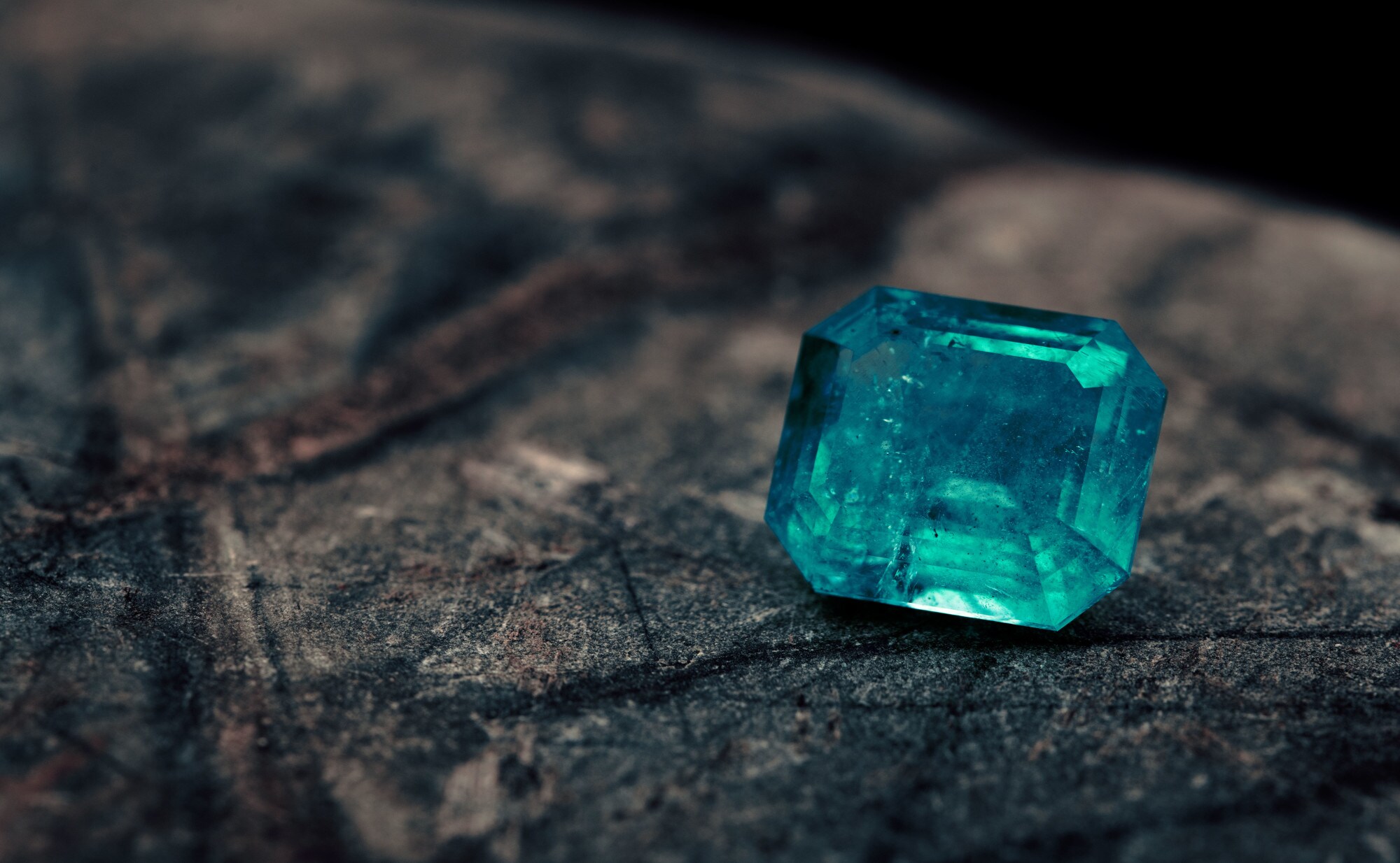 Ein hellblauer, geschliffener Saphir auf dunklem Grund