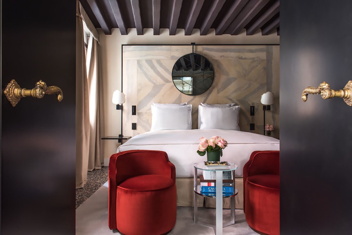 Stilvolles Hotelzimmer mit Doppelbett, im Vordergrund eine geöffnete Flügeltür mit goldenen Türklinken. Stilvolles Hotelzimmer mit Doppelbett, im Vordergrund eine geöffnete Flügeltür mit goldenen Türklinken.