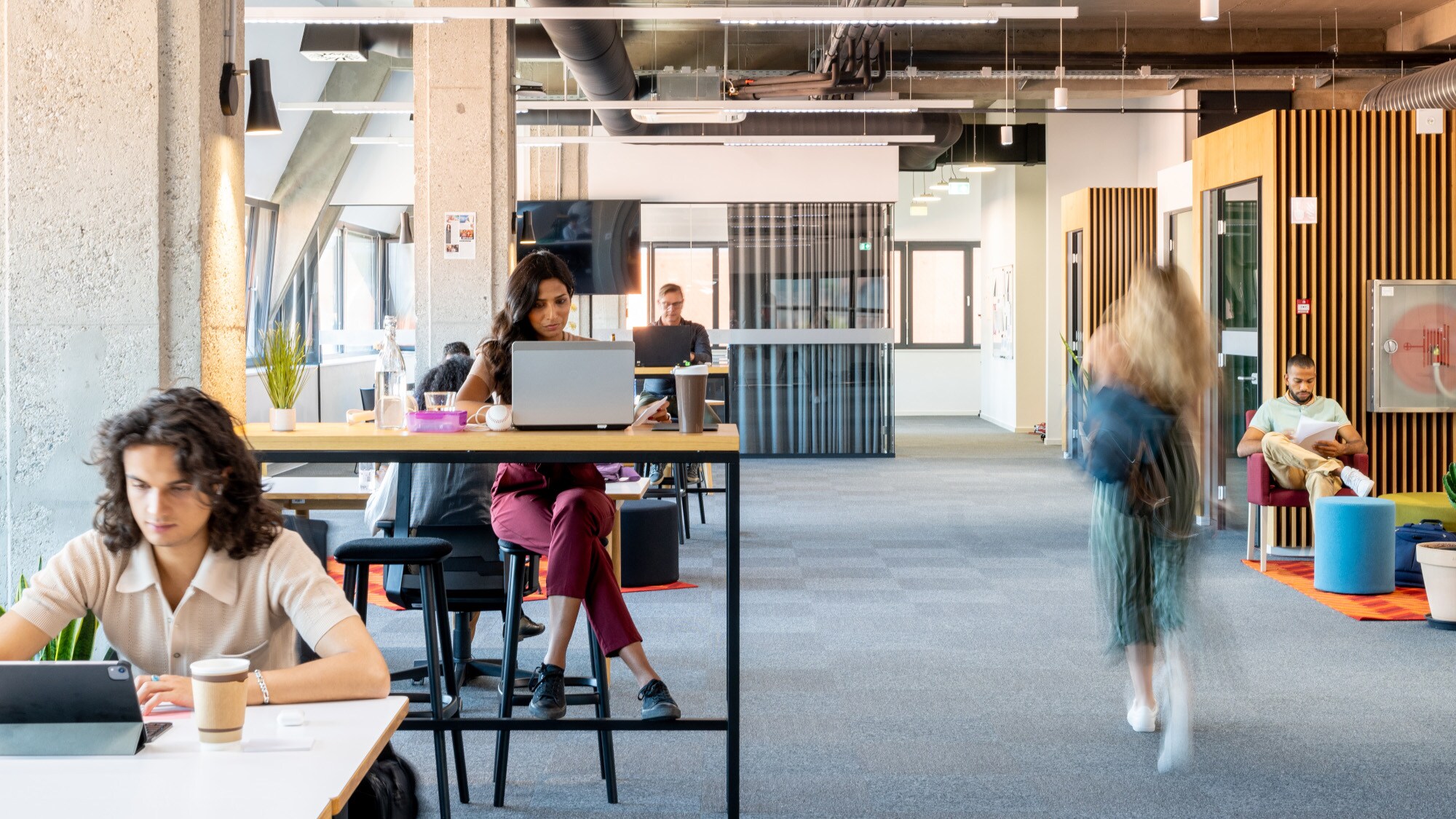 Mehrere Personen in einem modernen, loftartigen Co-Working-Space.