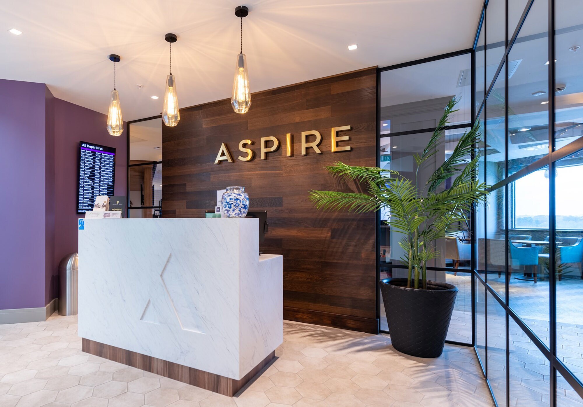 Eingangsbereich mit Rezeption einer Aspire Flughafenlounge.