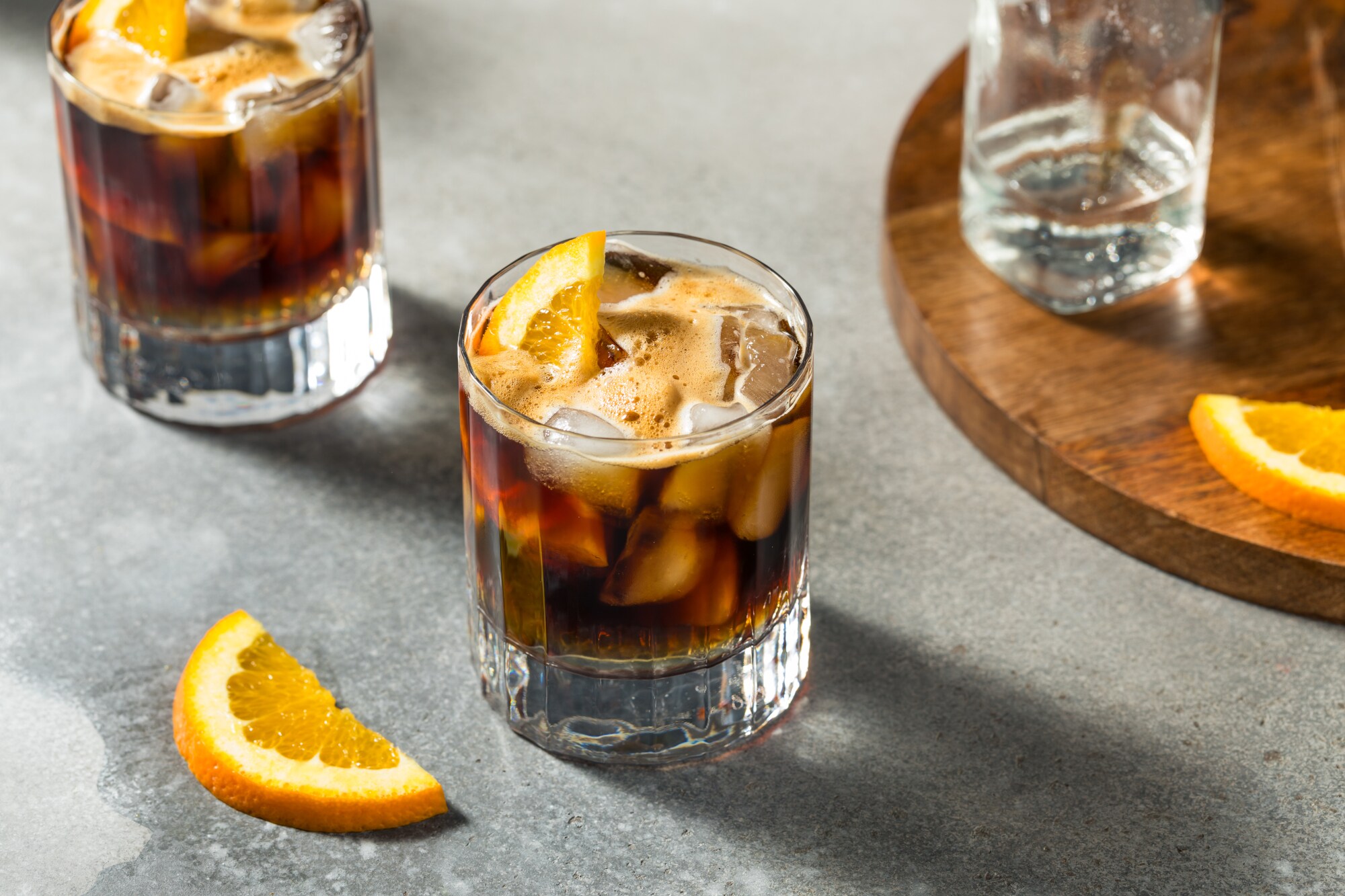 Zwei Gläser Espresso Tonic mit Eiswürfeln und Orangenscheiben.