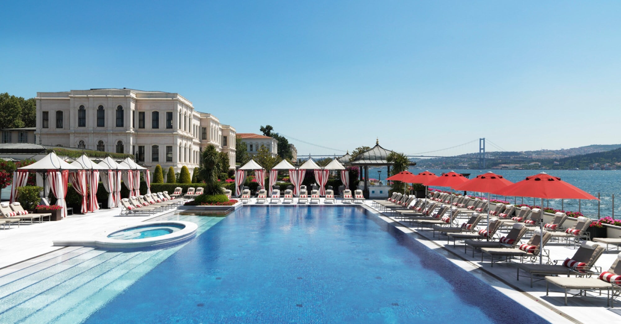 Großer Außenpool mit Liegestühlen auf der Terrasse eines noblen Hotels an einer Meeresbucht. Großer Außenpool mit Liegestühlen auf der Terrasse eines noblen Hotels an einer Meeresbucht.