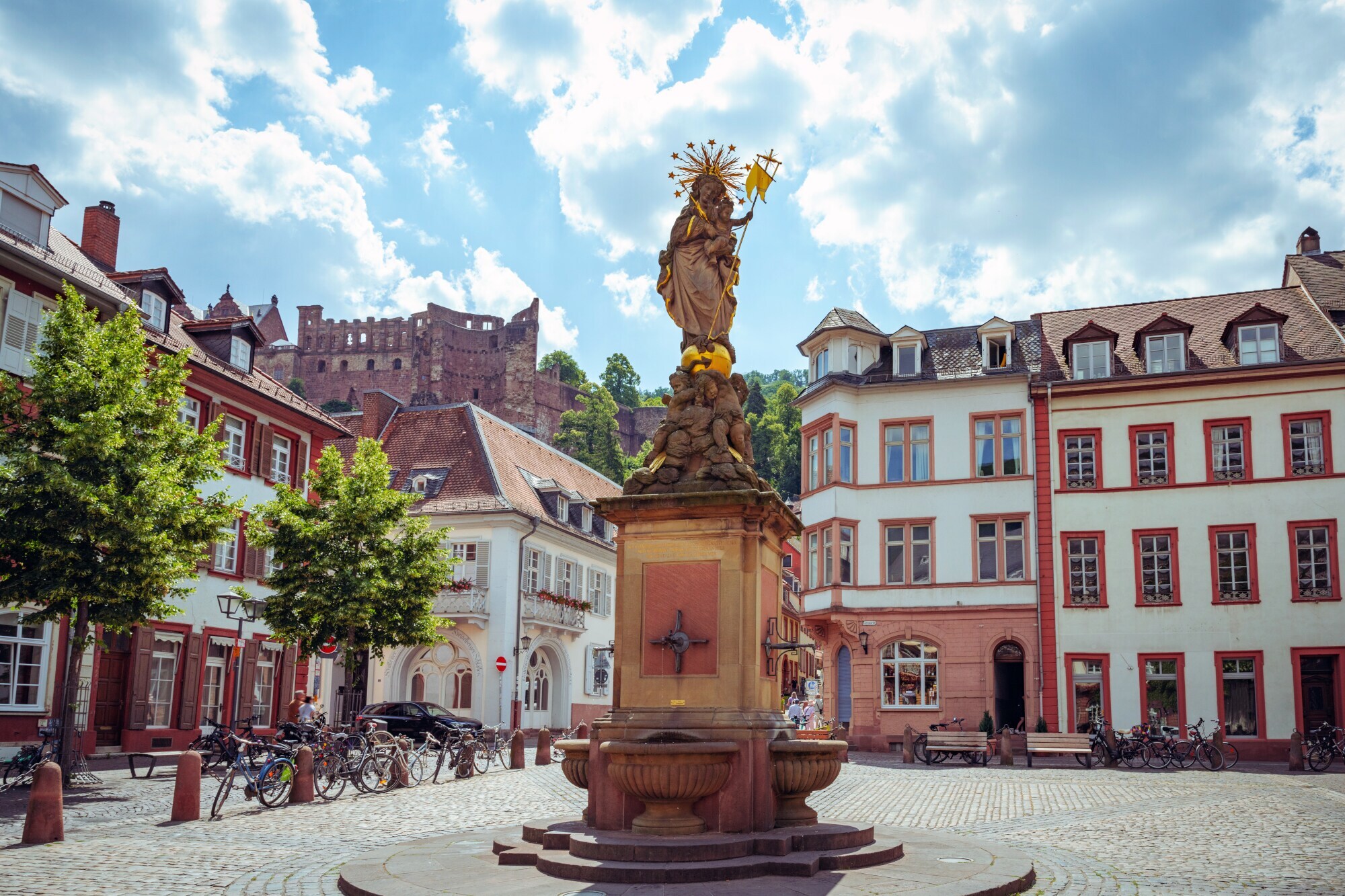 Platz mit Brunnen vor farbenfrohen Häusern in der Altstadt von Heidelberg.