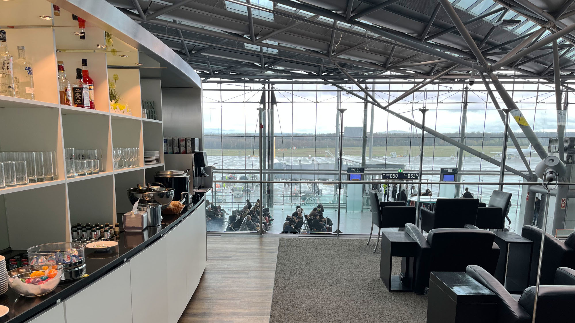 Flughafenlounge mit Buffet auf einer offenen Galerie in einem Flughafenterminal mit Blick aufs Rollfeld. Flughafenlounge mit Buffet auf einer offenen Galerie in einem Flughafenterminal mit Blick aufs Rollfeld.
