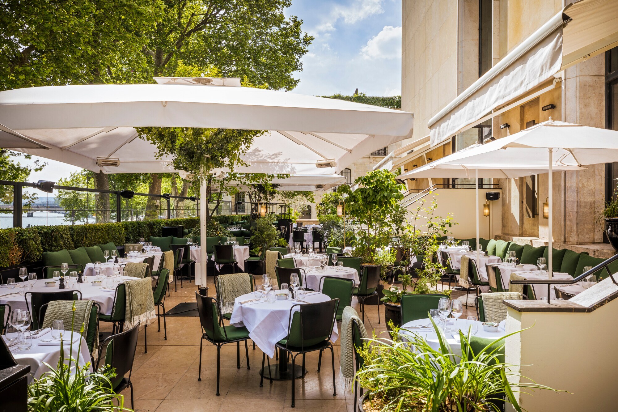 Terrasse eines gehobenen Restaurants mit eingedeckten Tischen.