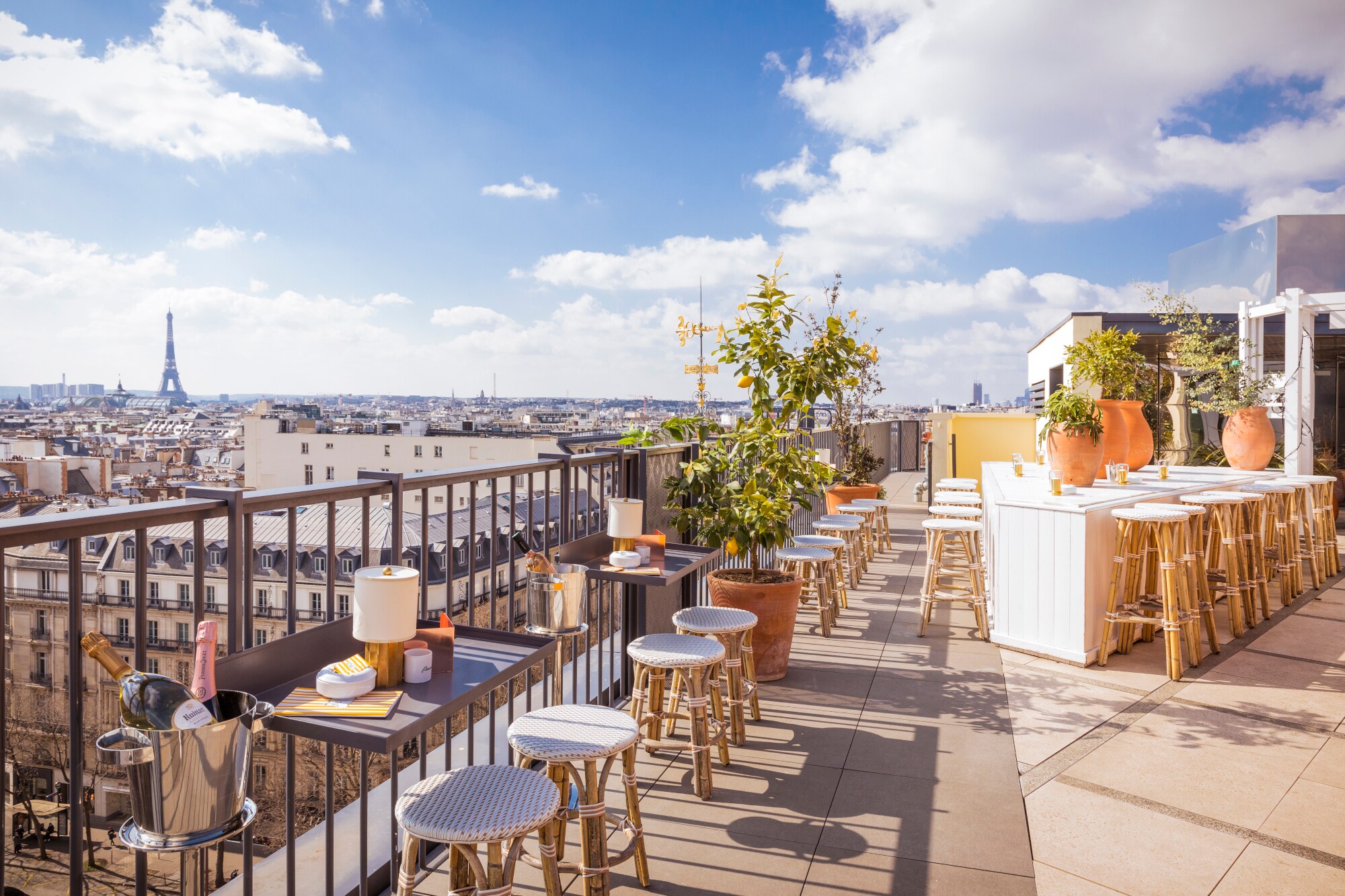 Dachterrasse des Restaurants Perruche mit Blick auf die Dächer von Paris und den Eiffelturm in der Ferne.