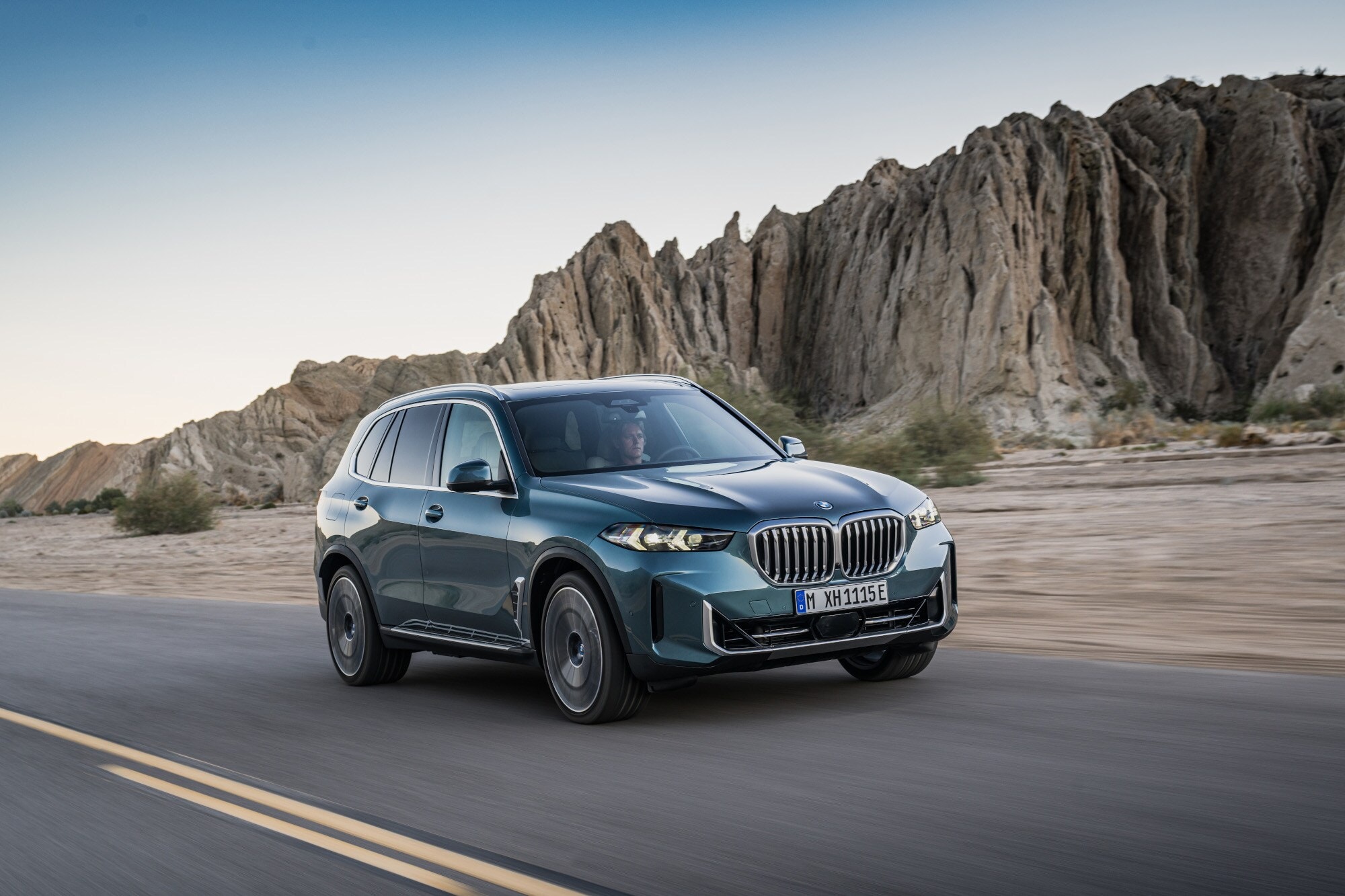 Ein blaugrauer BMW X5 auf einer Straße in Wüstenumgebung. Ein blaugrauer BMW X5 auf einer Straße in Wüstenumgebung.