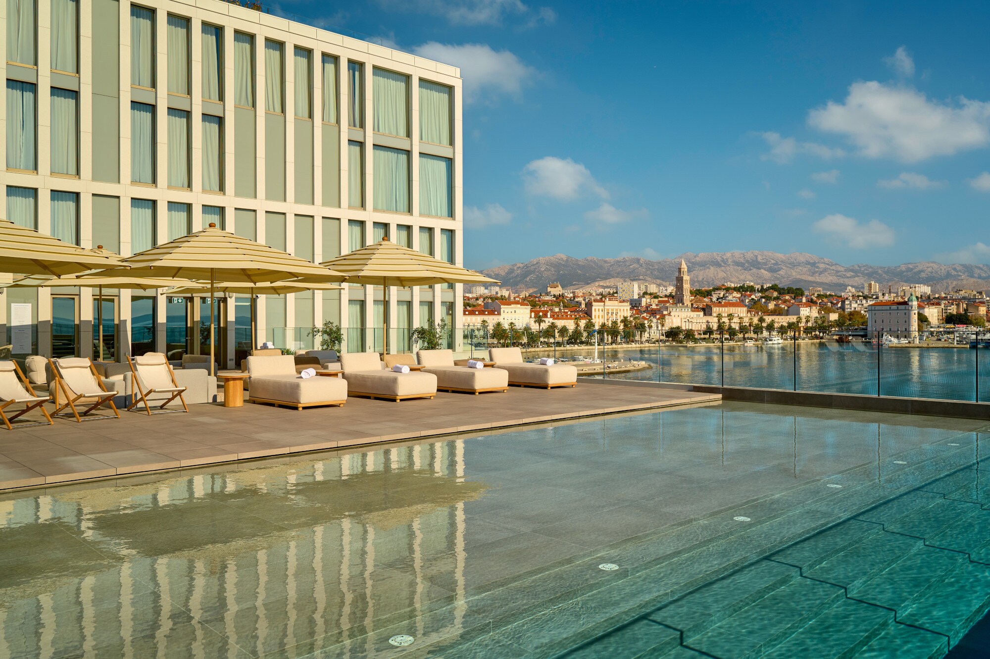 Großer Außenpool mit Liegestühlen auf der Terrasse des Hotel Ambasador in Split. Großer Außenpool mit Liegestühlen auf der Terrasse des Hotel Ambasador in Split.