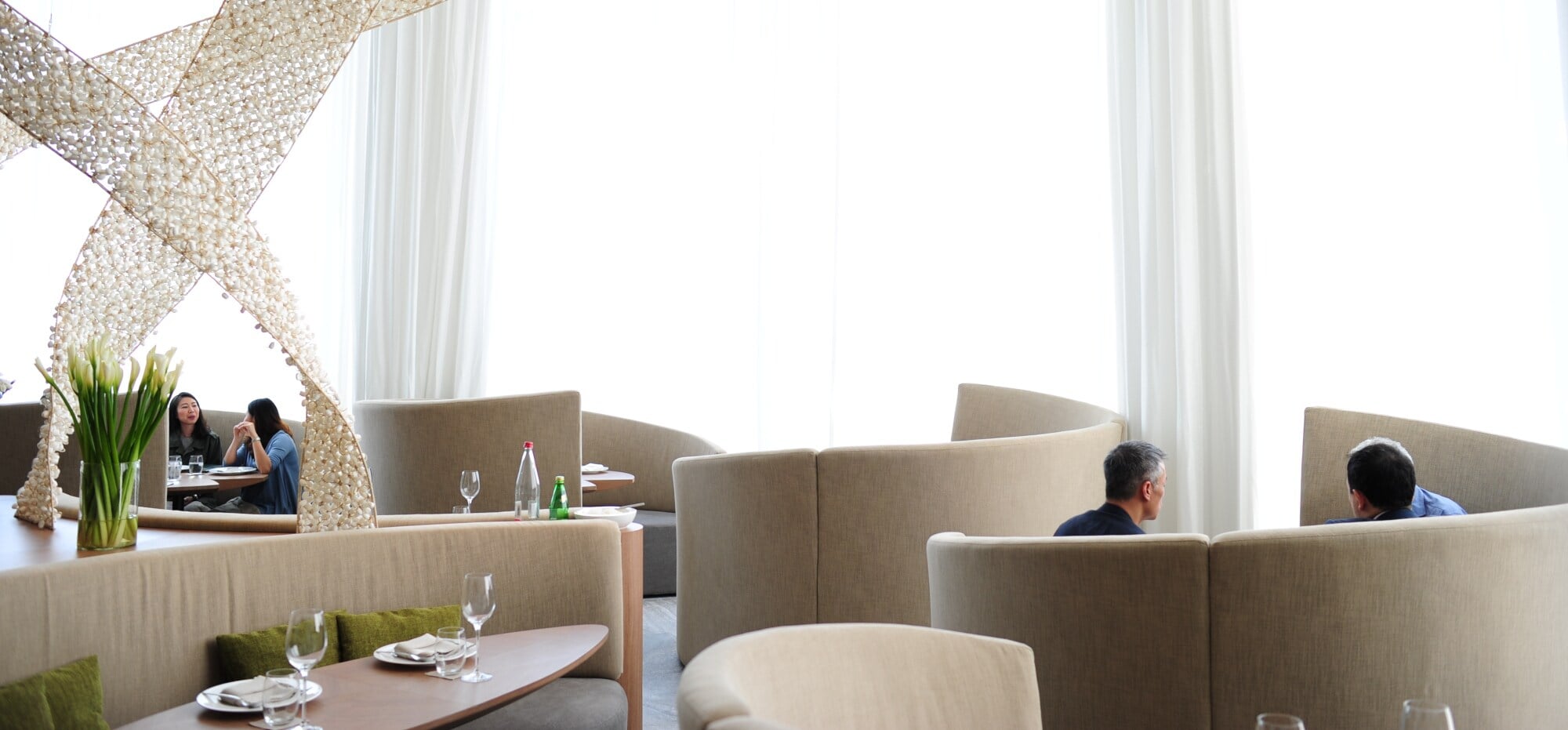 Heller Speiseraum des Restaurants Paste mit gedeckten Tischen und spiralförmiger Skulptur. Heller Speiseraum des Restaurants Paste mit gedeckten Tischen und spiralförmiger Skulptur.