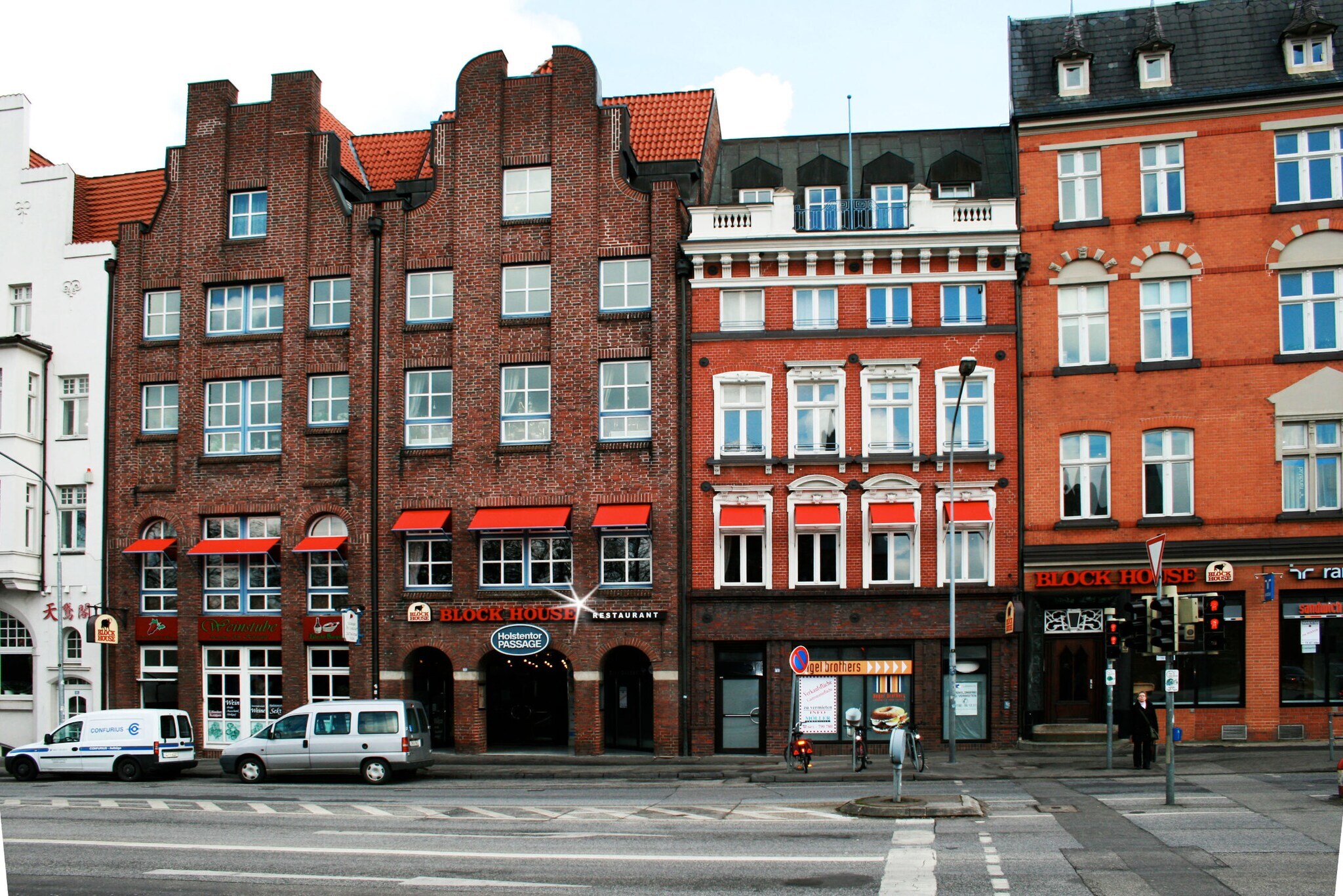 Häuserfront mit Giebelhäusern aus Rotsteinklinker mit Block House Schriftzug.