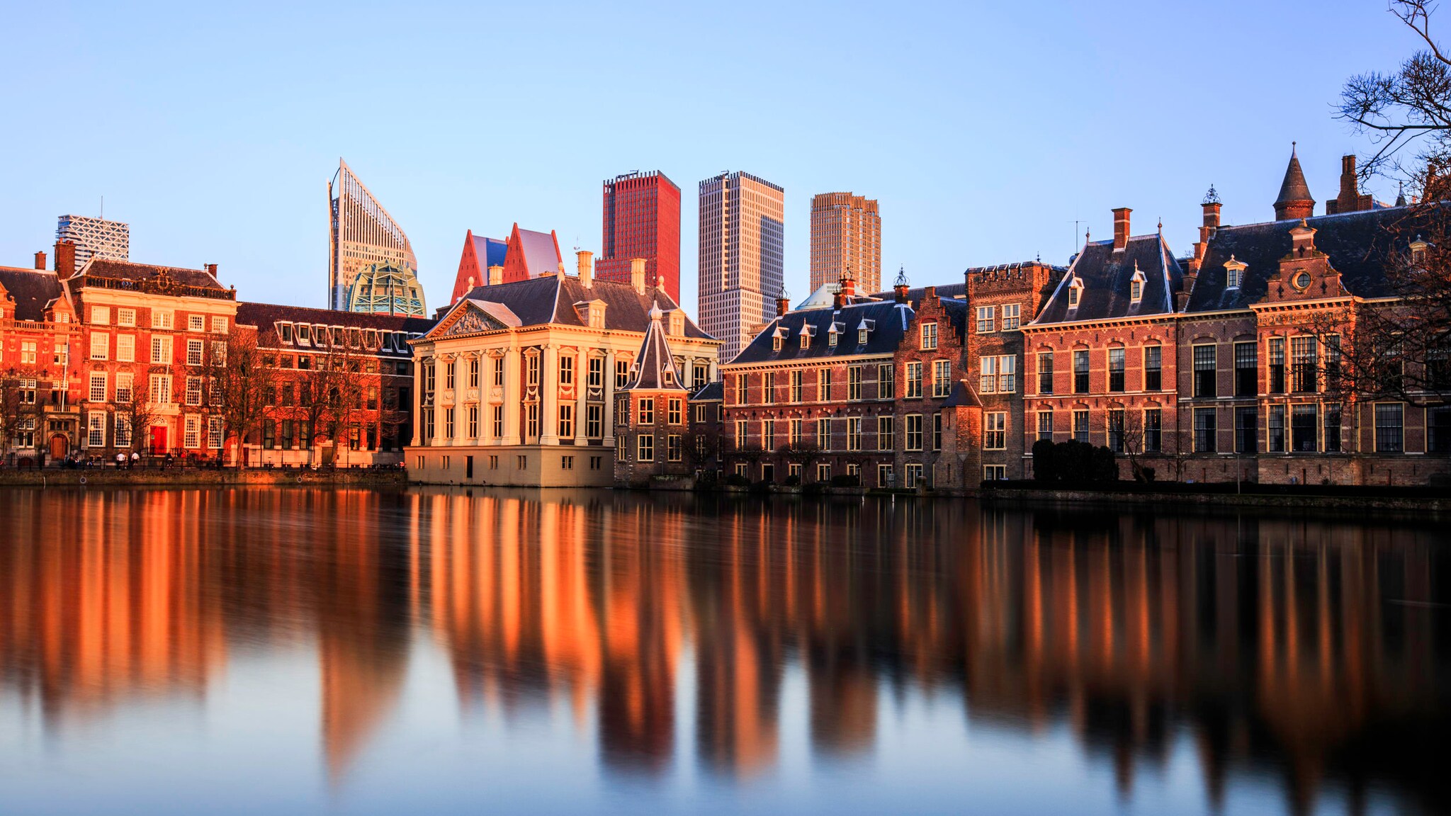 Skyline von Den Haag bei Sonnenuntergang, die Gebäude spiegeln sich im Wasser. Skyline von Den Haag bei Sonnenuntergang, die Gebäude spiegeln sich im Wasser.