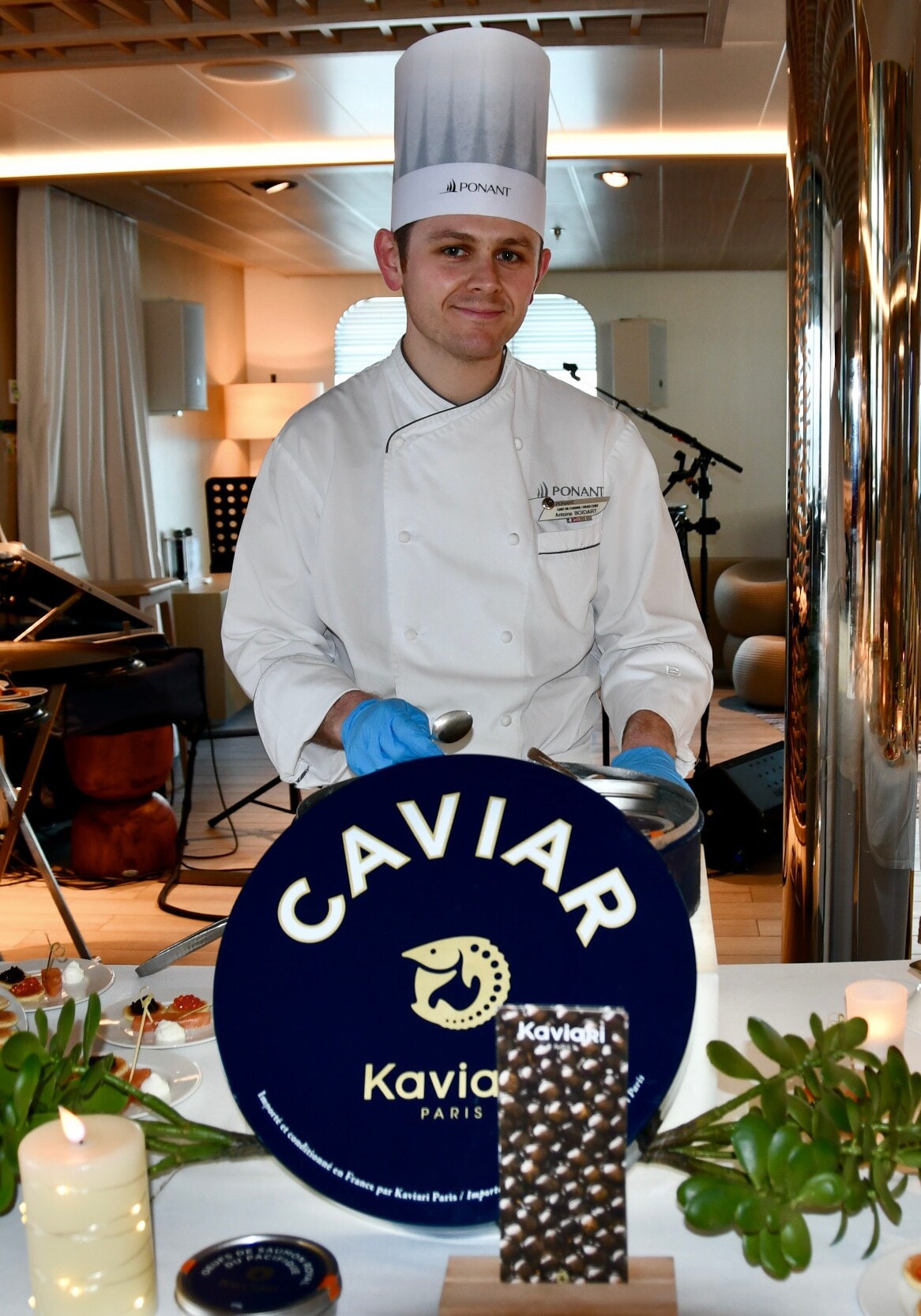 Das Bild zeigt einen Koch vor einem reich gedeckten Buffet, der den Gäste Kaviar anbietet. Das Bild zeigt einen Koch vor einem reich gedeckten Buffet, der den Gäste Kaviar anbietet.