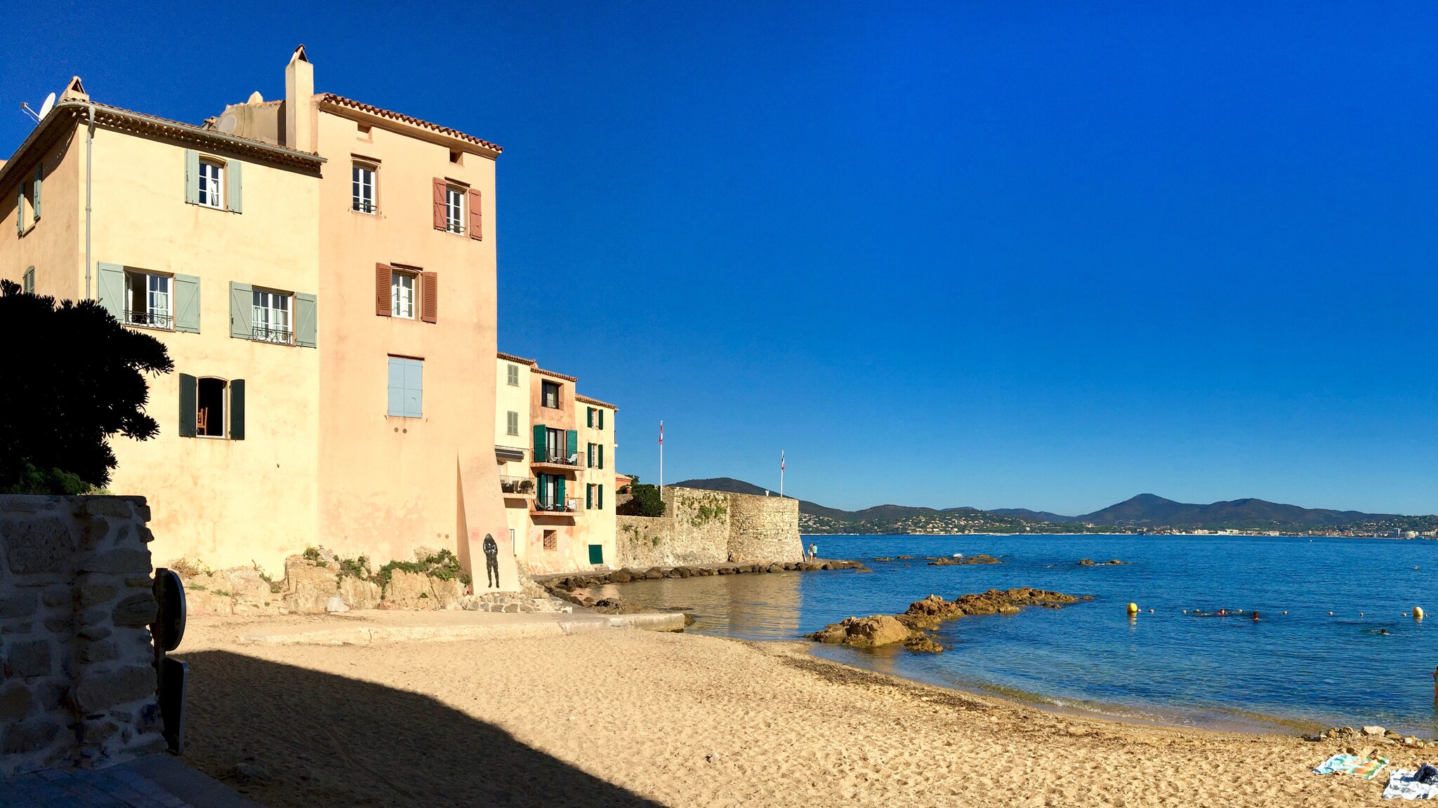Kleine, menschenleere Strandbucht, umgeben von pastellfarbenen Häusern in mediterraner Umgebung. Kleine, menschenleere Strandbucht, umgeben von pastellfarbenen Häusern in mediterraner Umgebung.