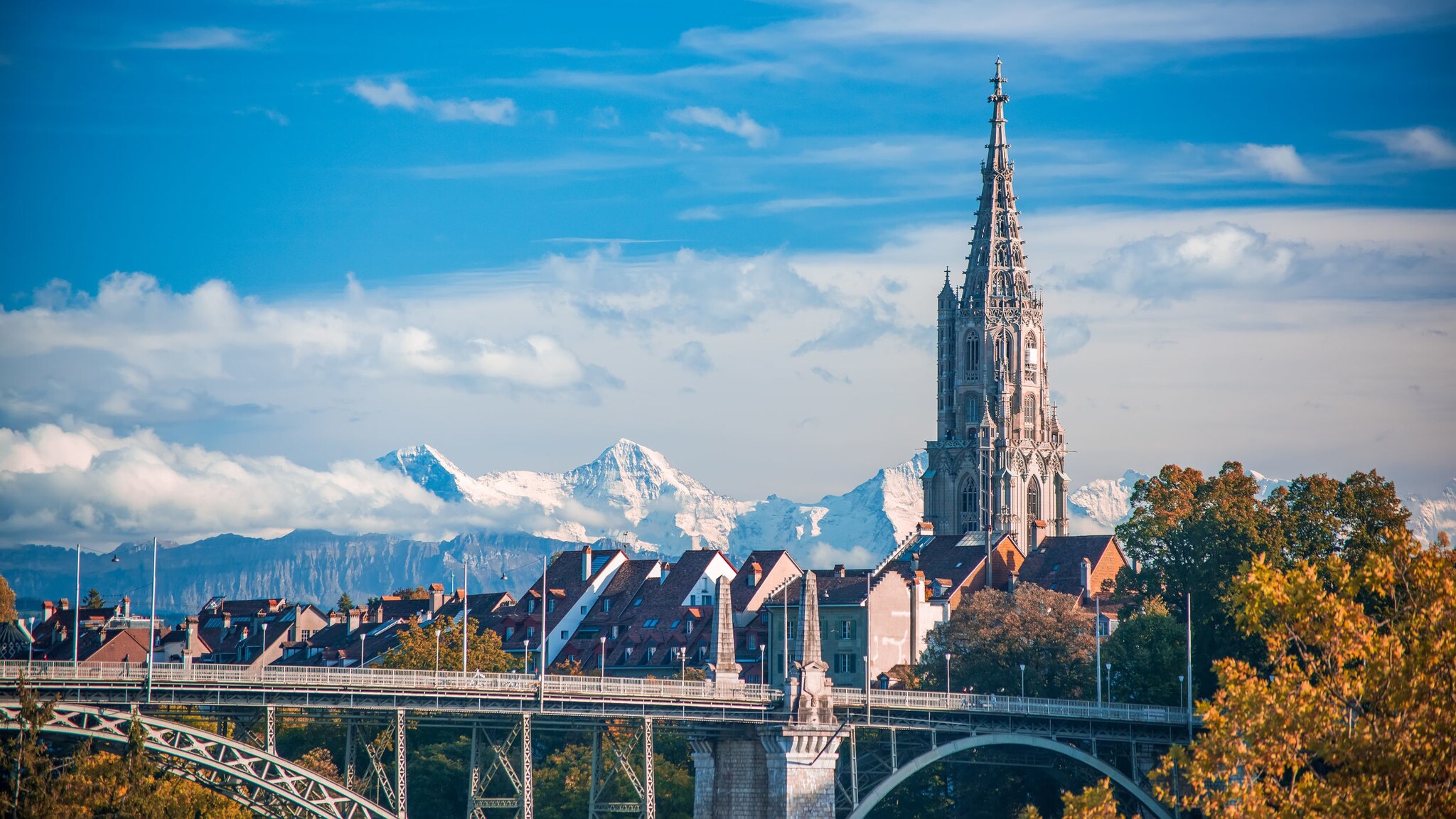 Turm der Kathedrale von Bern mit schneebedeckten Gipfeln im Hintergrund. Turm der Kathedrale von Bern mit schneebedeckten Gipfeln im Hintergrund.