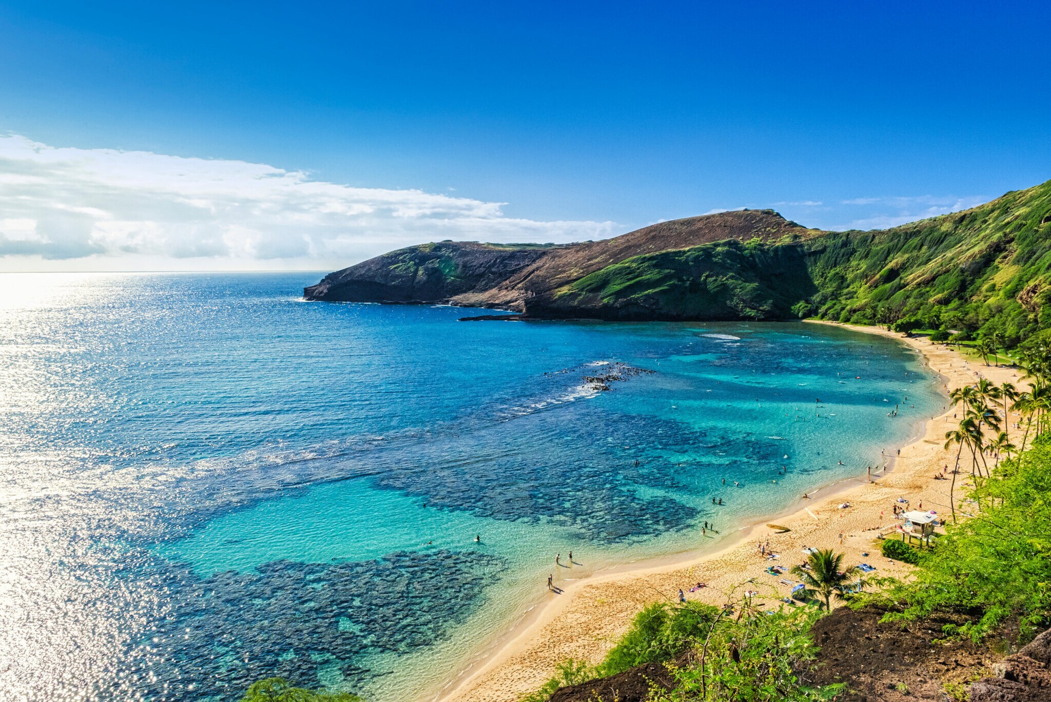 Felsenbucht mit Sandstrand und ruhigem, türkisblauem Wasser.