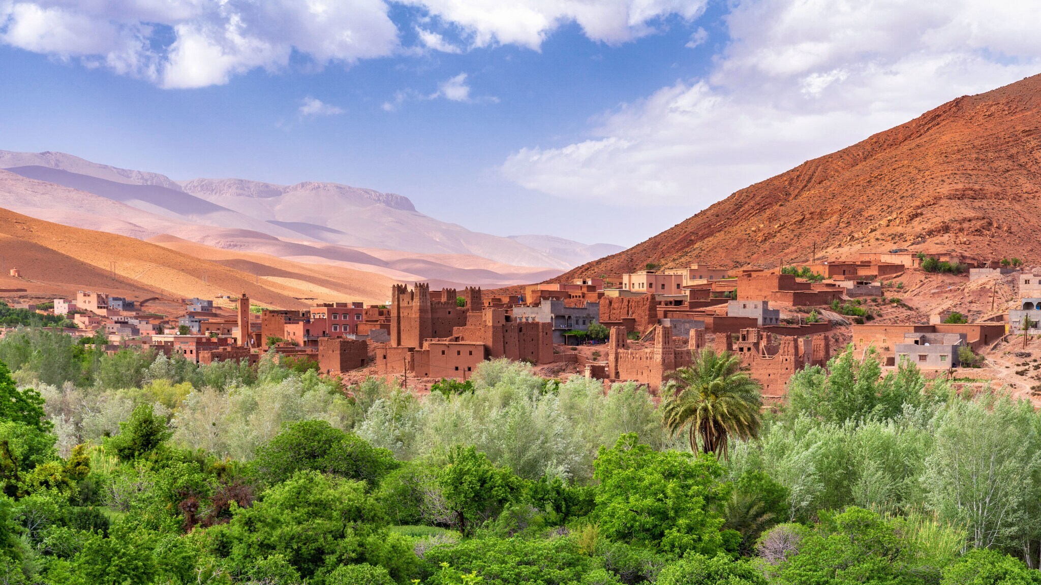 Berberstadt mit grüner Oase vor Wüstengebirge.