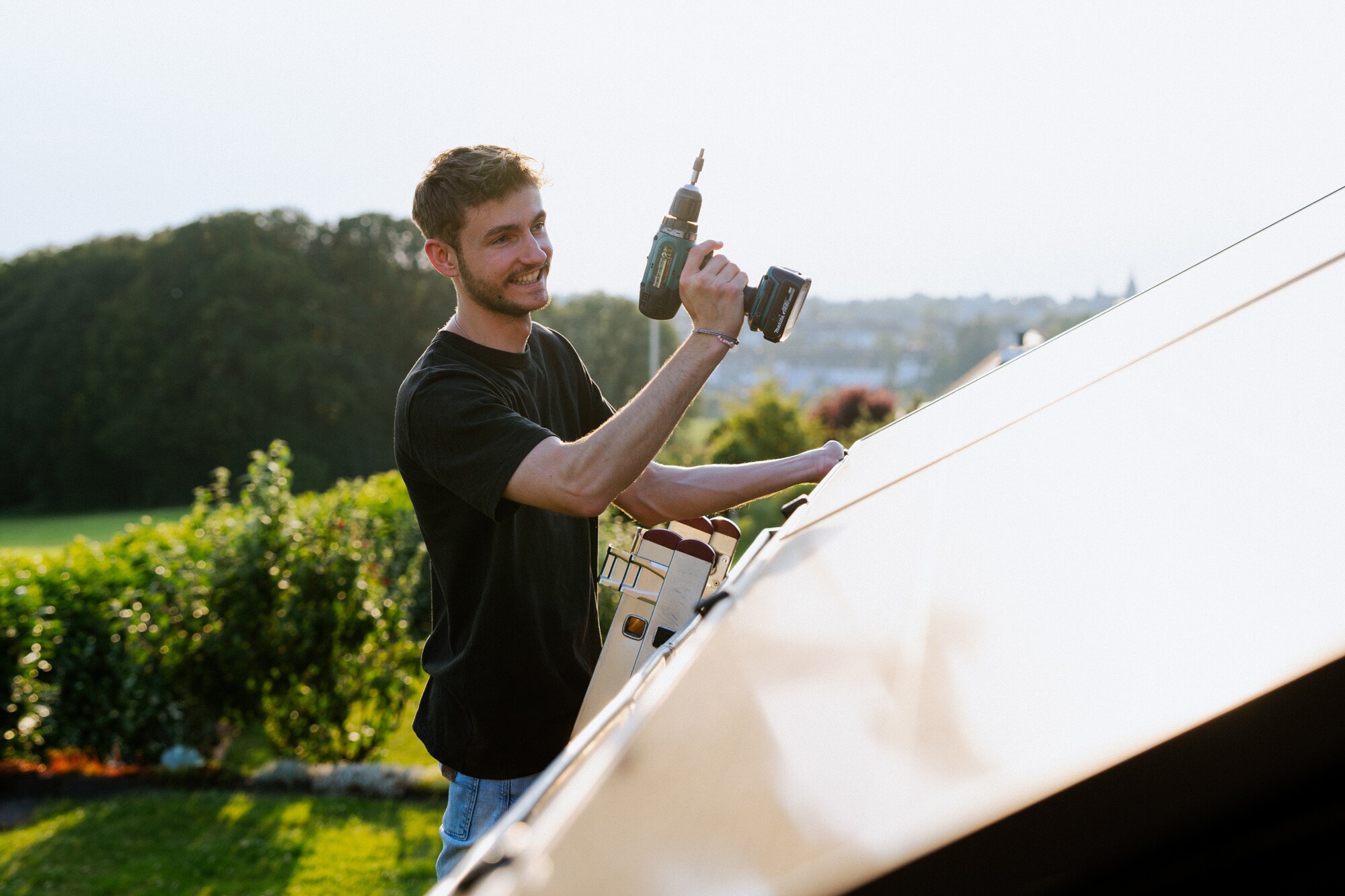 Janik Nolden, Co-Gründer der solago GmbH, arbeitet am Dach eines Hauses.