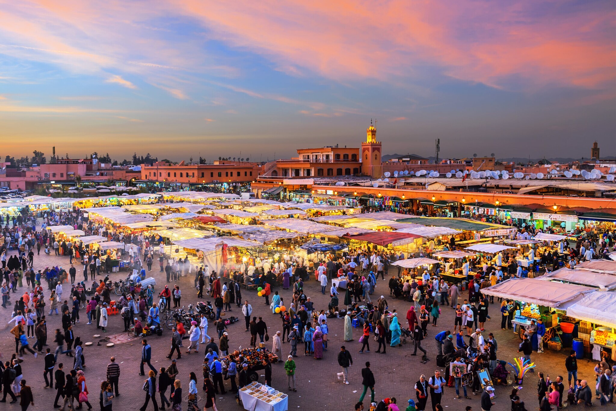 Belebter Marktplatz im Zentrum Marrakeschs am Abend.