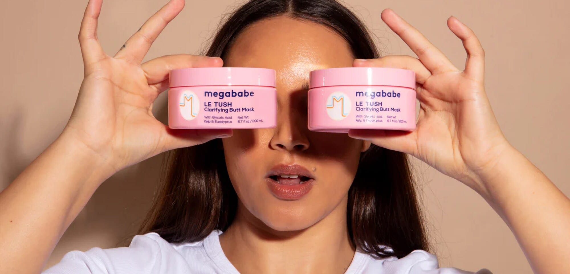 Let’s Disrupt the Market: 5 erfolgreiche Business-Ideen, die Tabus brechen Foto einer jungen Frau, die sich zwei Produkte der Marke megababe vor ihr Gesicht hält.