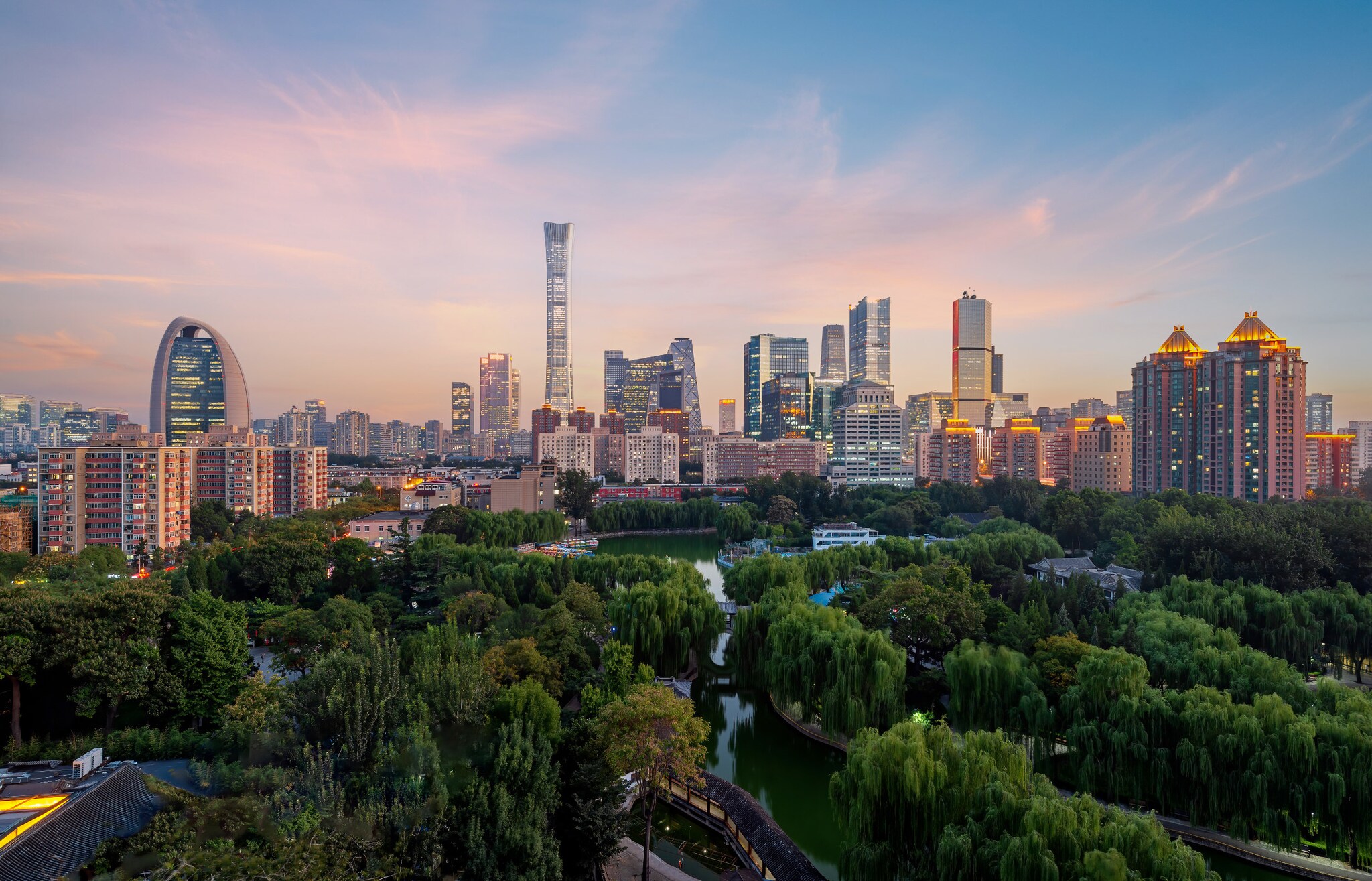 Erleuchtete Skyline von Peking mit Parkanlage in der Dämmerung.