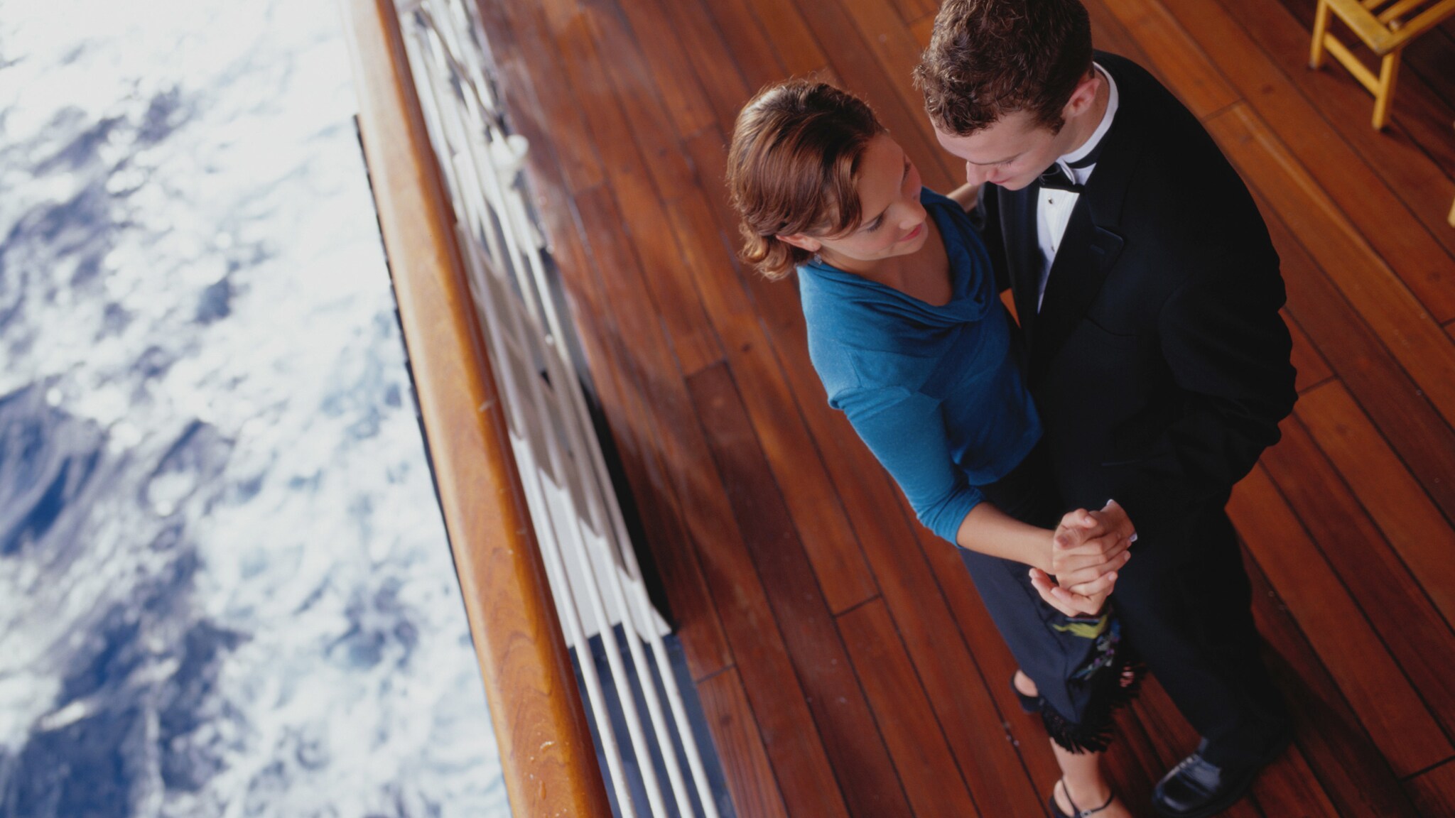 Aufsicht eines tanzenden Paares in Abendgarderobe an der Reling eines Schiffes auf dem Meer. Aufsicht eines tanzenden Paares in Abendgarderobe an der Reling eines Schiffes auf dem Meer.