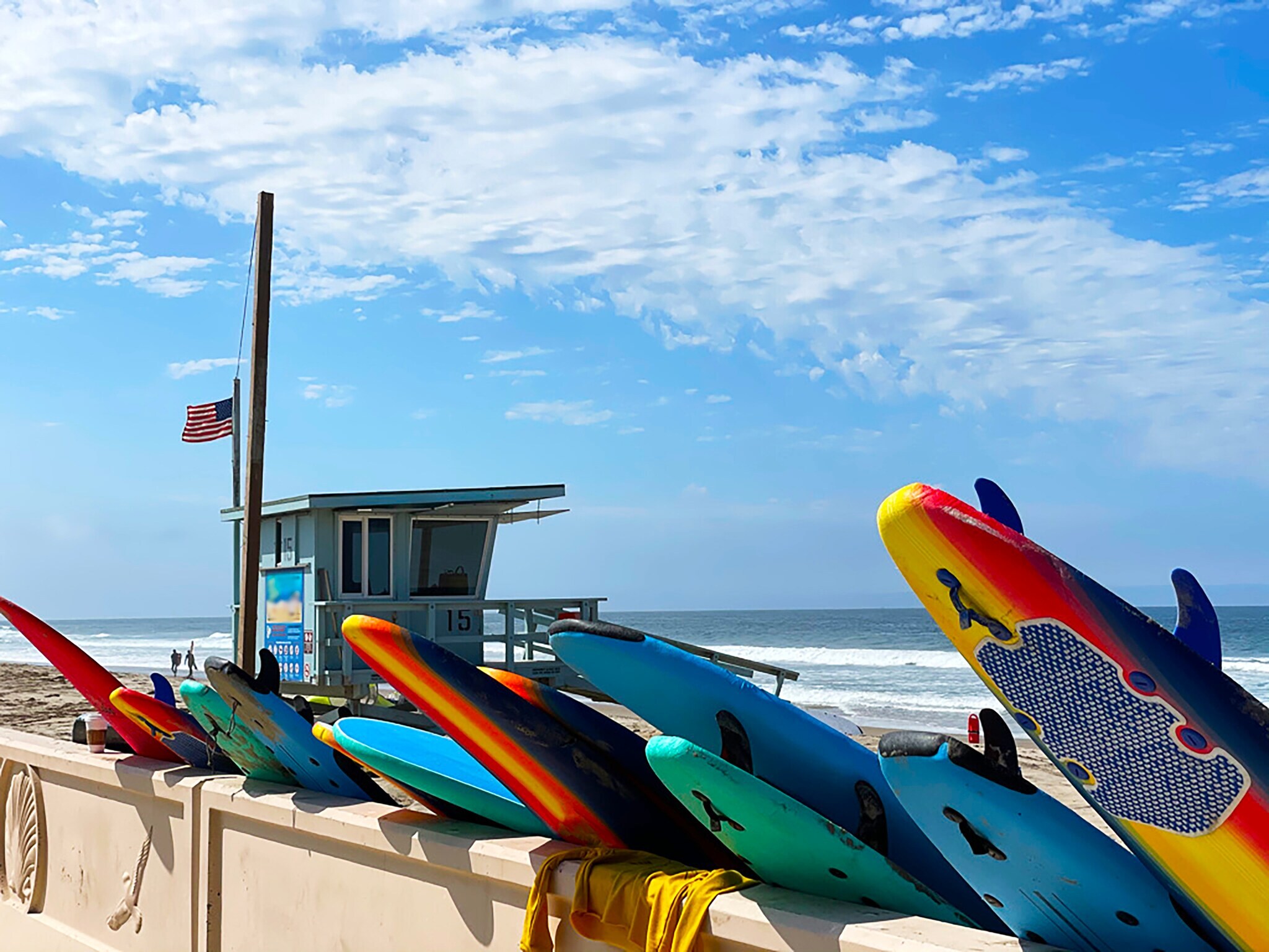 Bunte Surfbretter vor hellblauem Rettungsschwimmerturm am bekannten Zuma Beach in Malibu