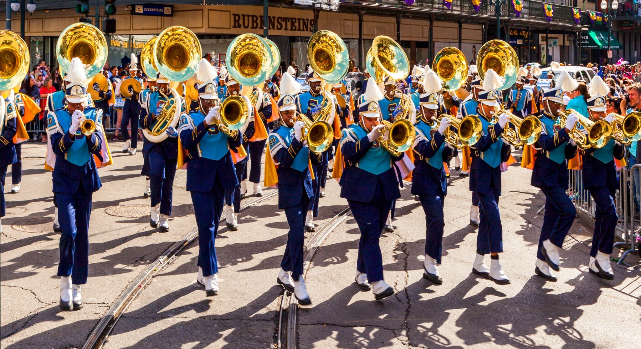 Eine Gruppe Musiker in blauen Uniformen mit Trompeten auf der Straße in einer Stadt.