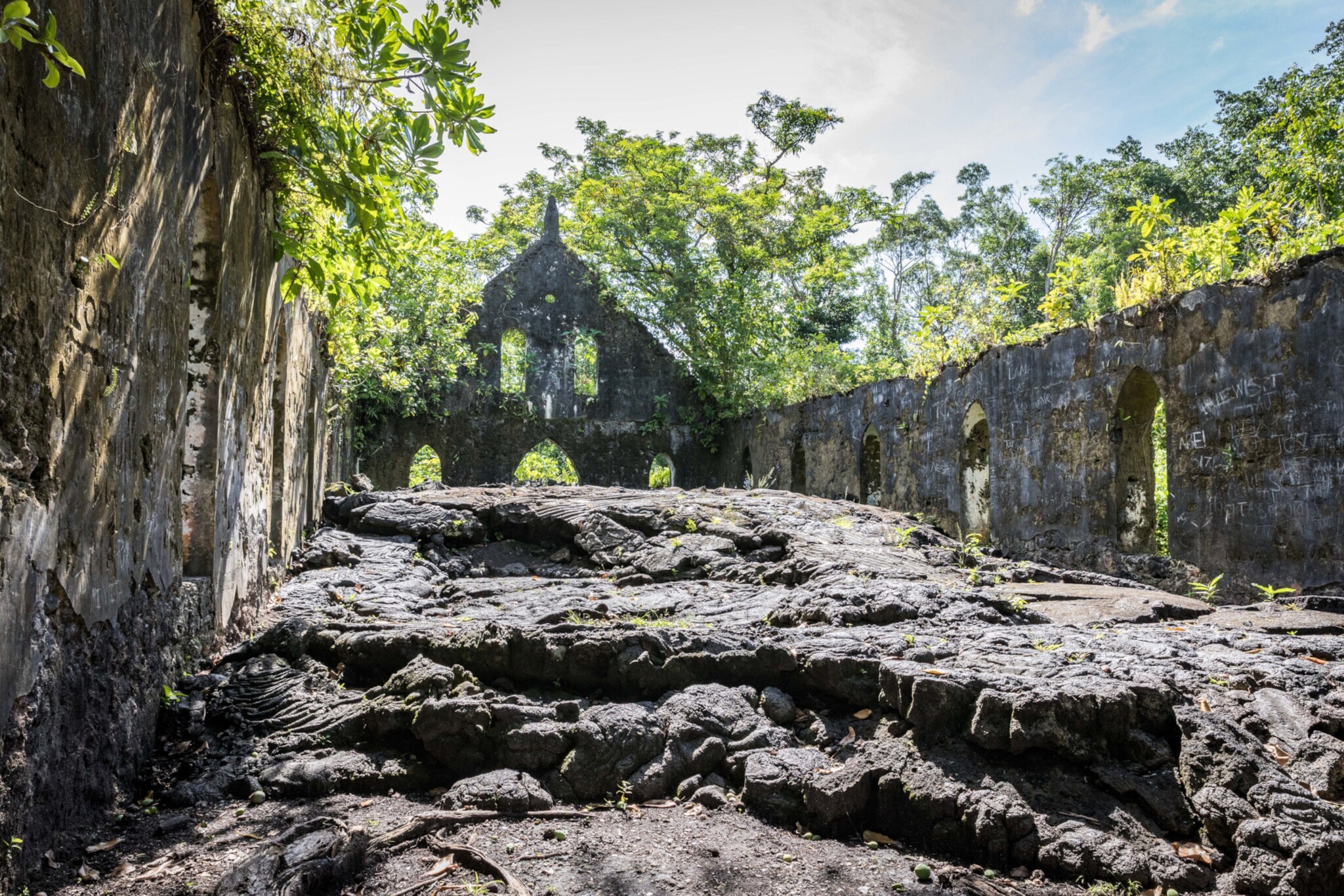 Steinruine einer Kirche mit Lavaüberresten, umgeben von tropischer Natur. Steinruine einer Kirche mit Lavaüberresten, umgeben von tropischer Natur.