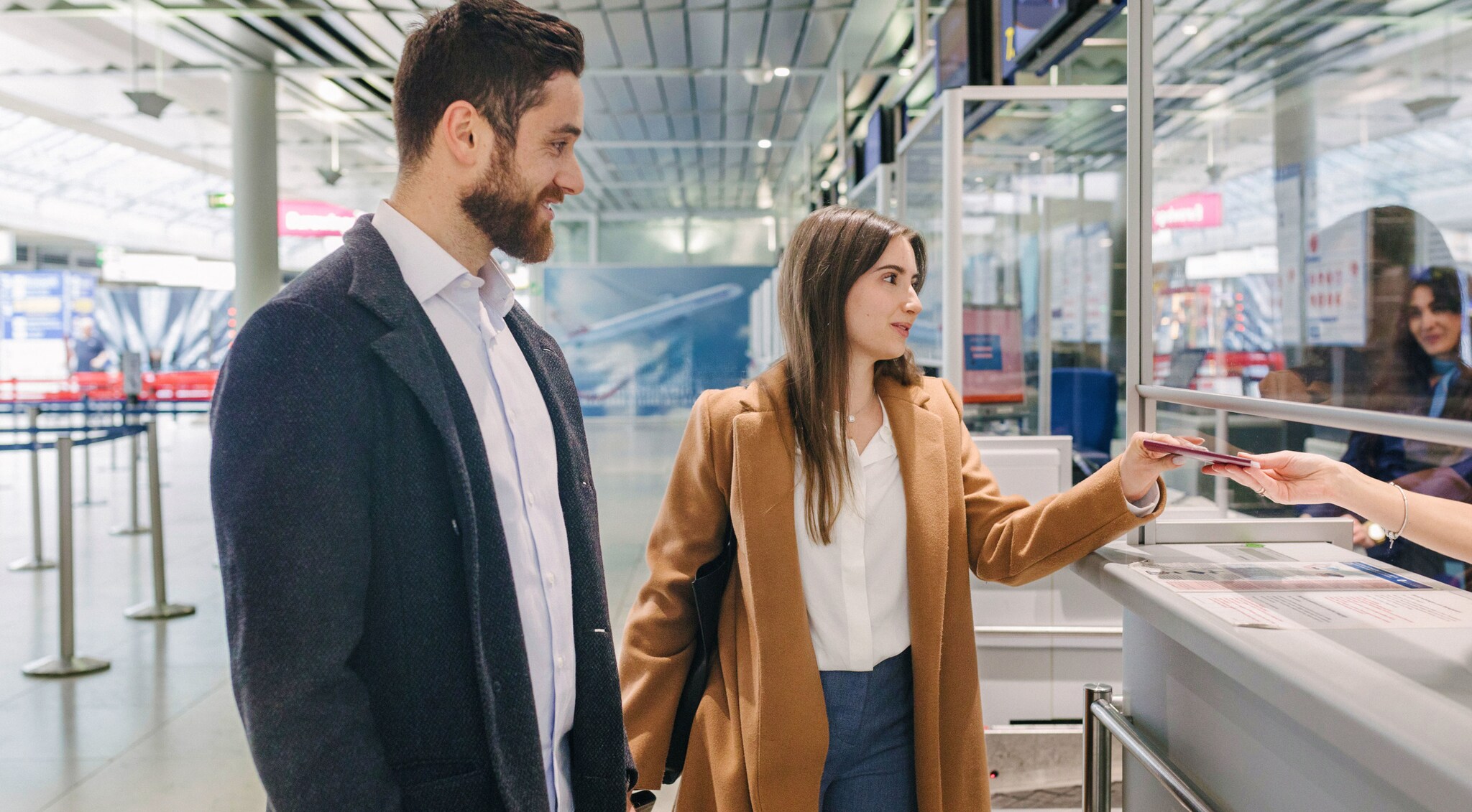 Ein Paar an der Passkontrolle in einem Flughafenterminal.