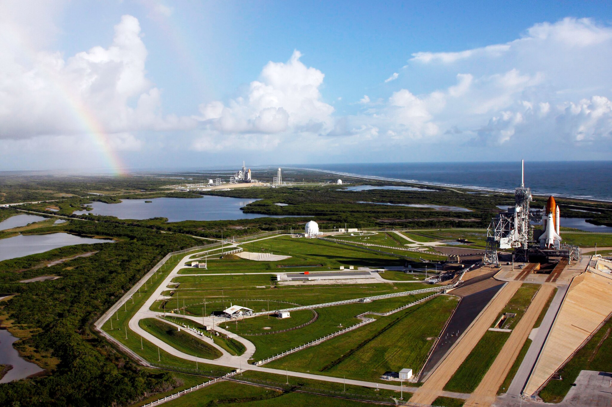 Weitläufiges Areal mit Raketenstartplatz, umgeben von Grünflächen am Wasser.