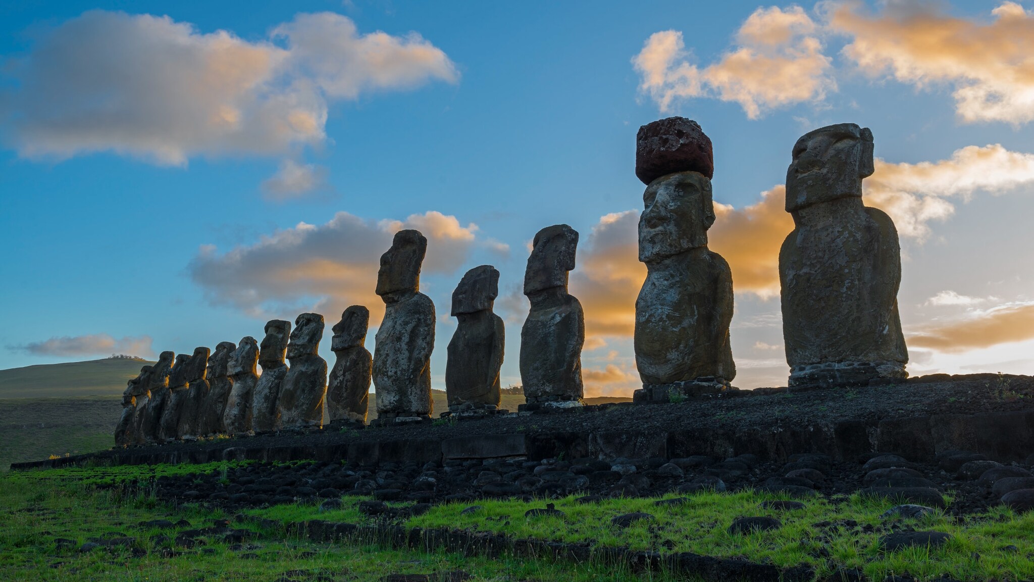 Eine Reihe von Moai-Steinfiguren auf der Osterinsel bei Sonnenaufgang.