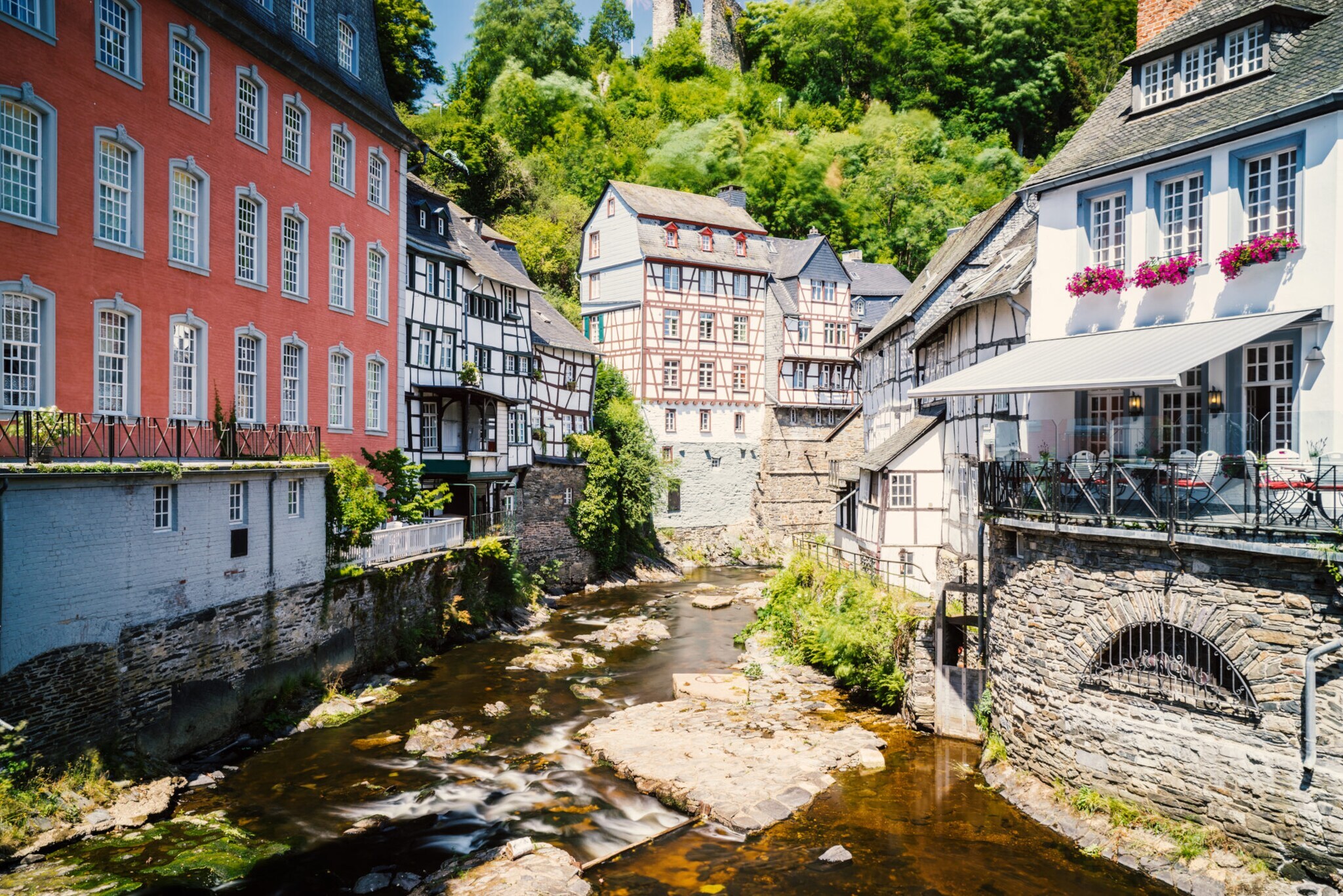 Blick auf Fachwerkhäuser an einem kleinen Fluss in der historischen Altstadt von Monschau.
