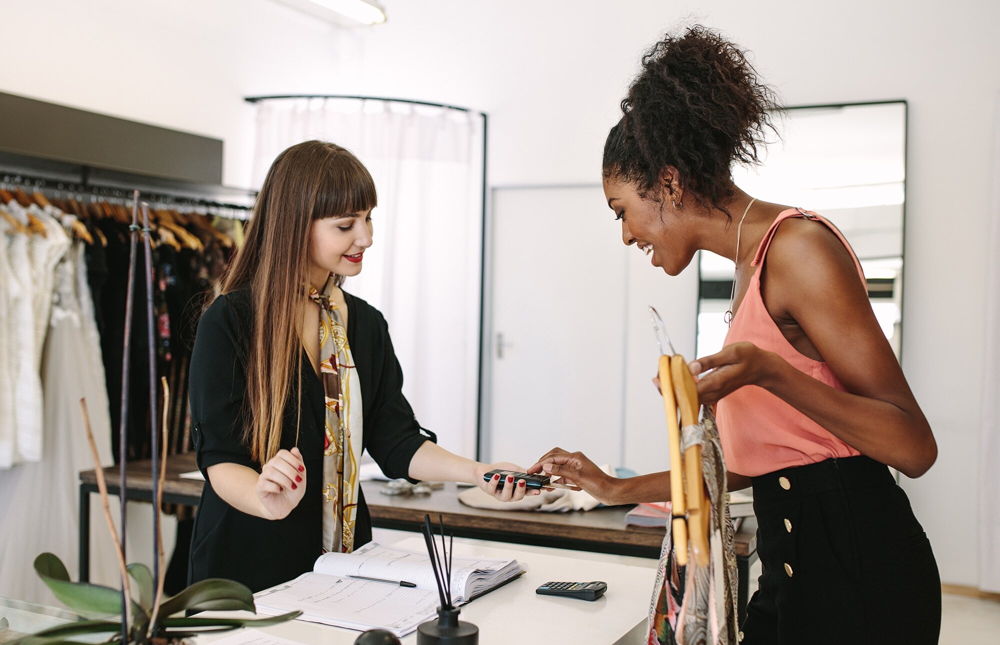 Visual Merchandising: Dein Laden, deine Bühne! Eine junge Frau bezahlt in einer Boutique ihren Einkauf.